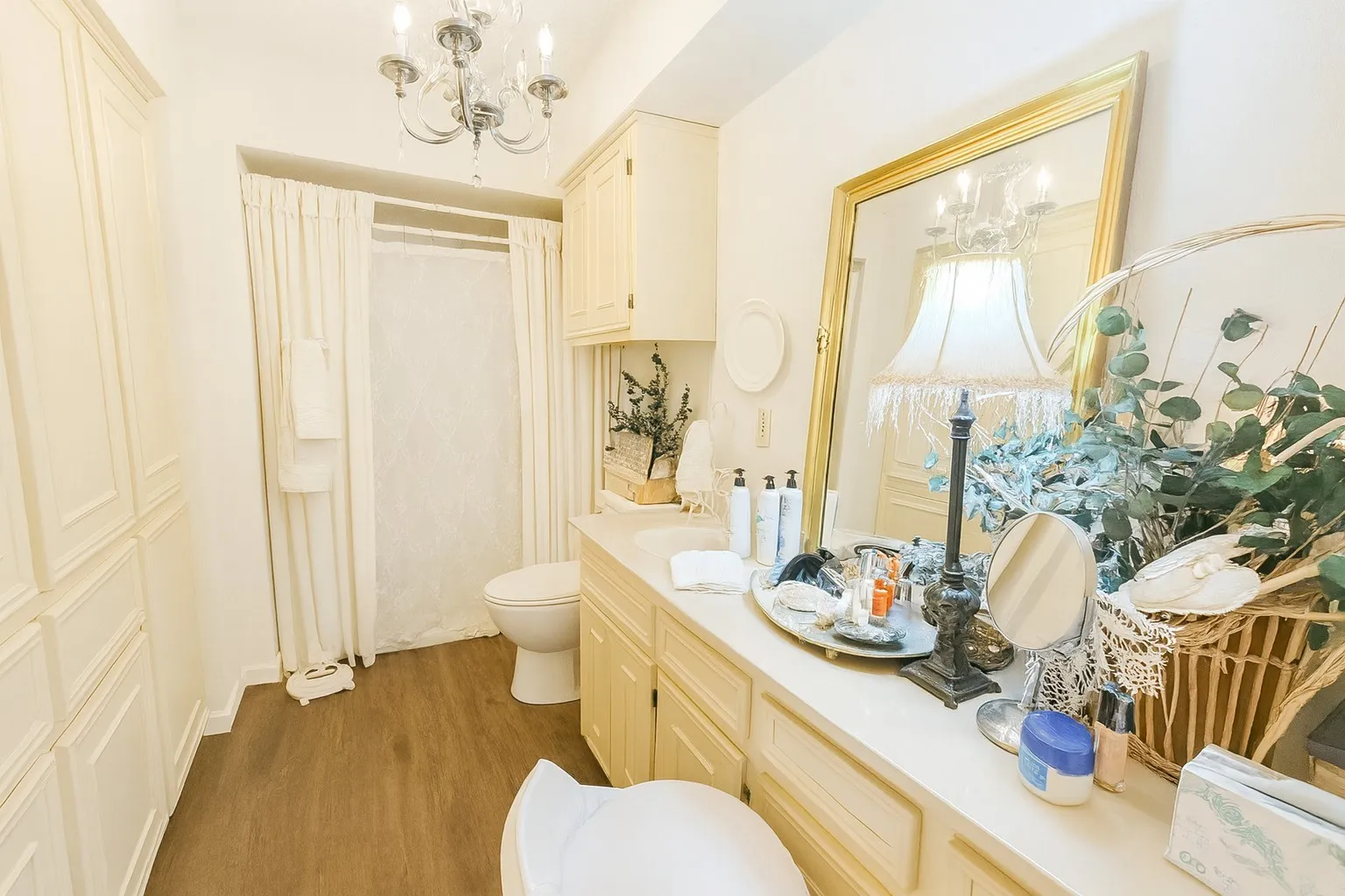 Bathroom with a shower with shower curtain, vanity, a chandelier, and dark wood-type flooring