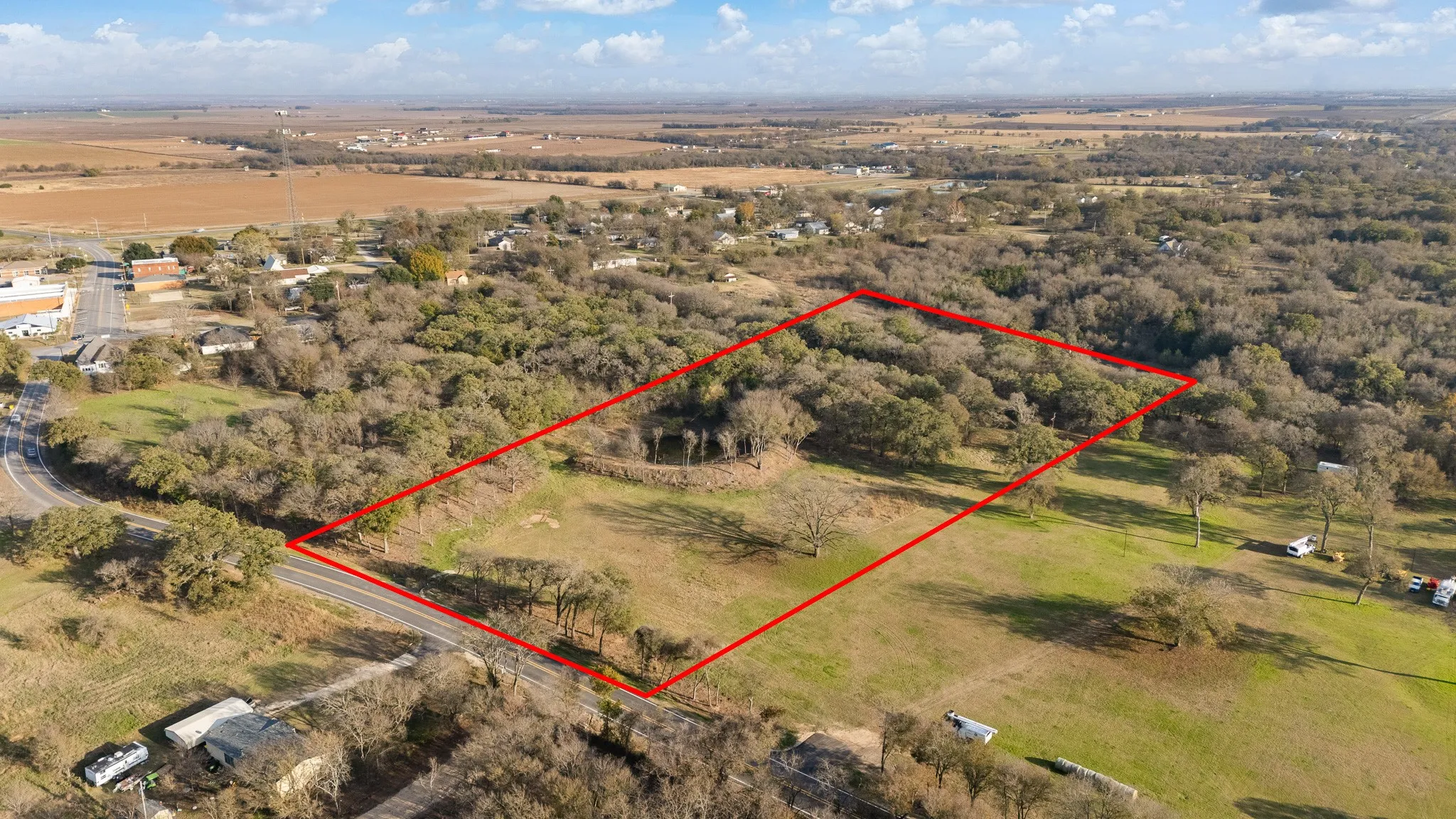 Aerial view of sparsely populated area with property parcel outlined