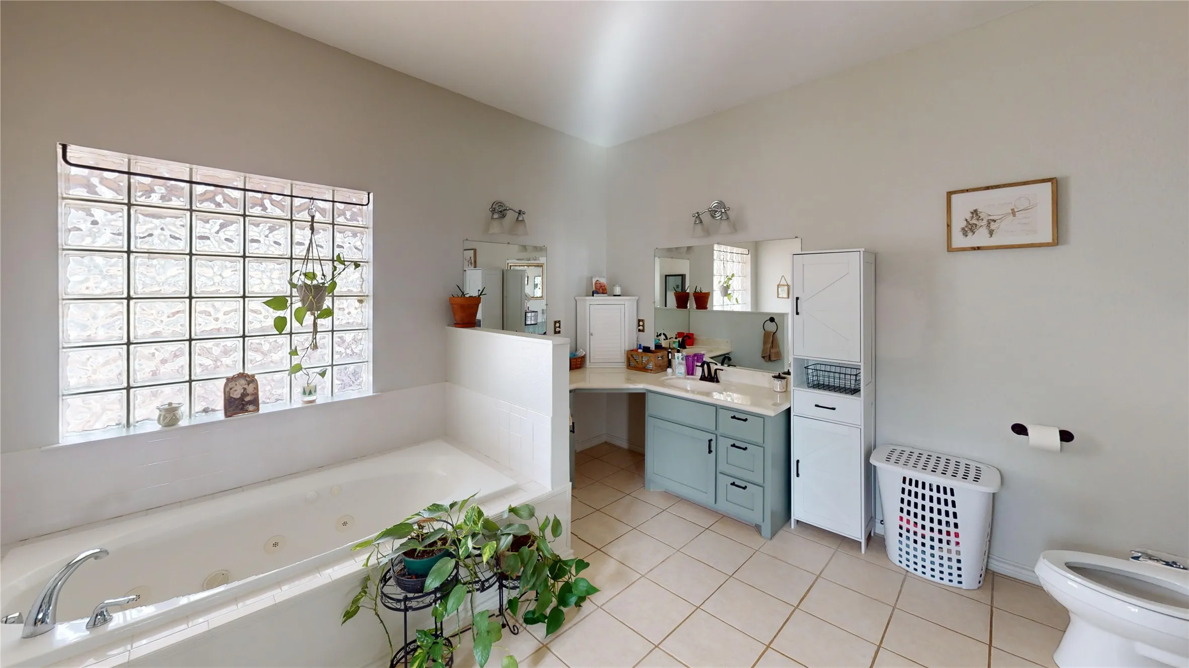 Bathroom with vanity, a tub with jets, light tile patterned floors, and a bidet