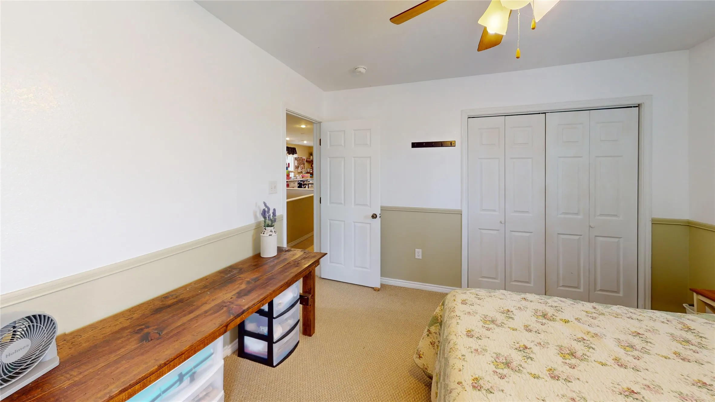 Bedroom with light colored carpet, ceiling fan, and a closet