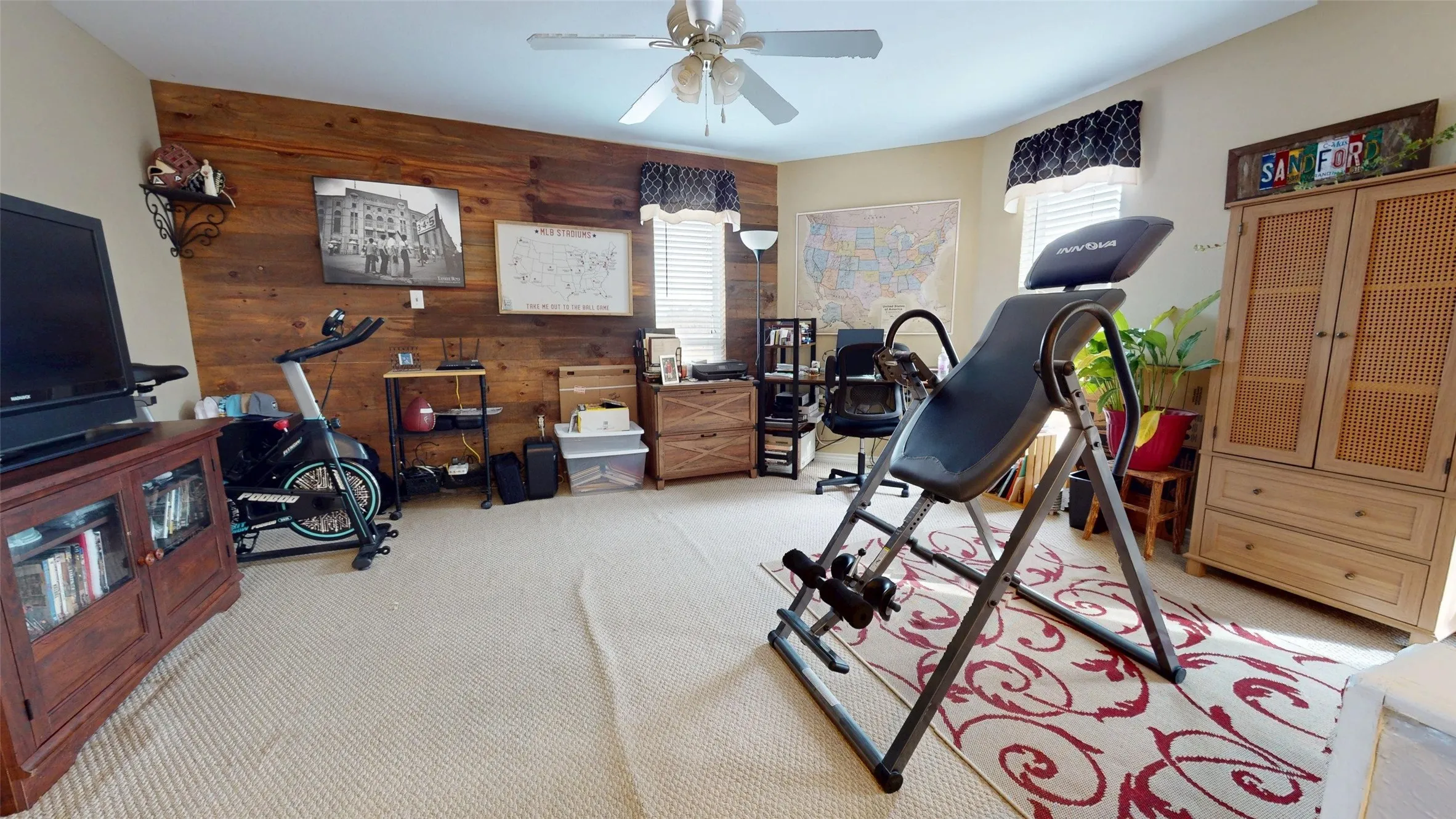 Workout room with wood walls, carpet flooring, healthy amount of natural light, and an accent wall