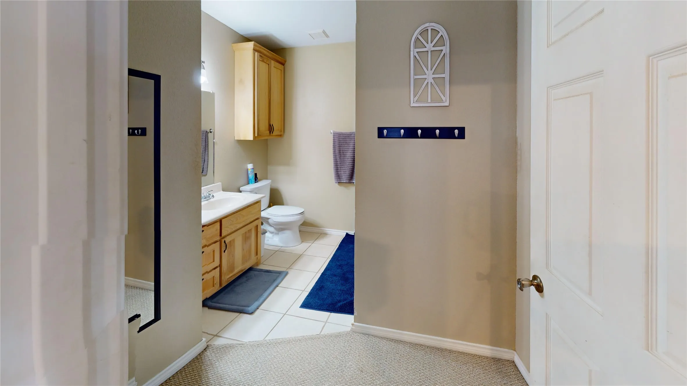 Bathroom with light tile patterned floors and vanity