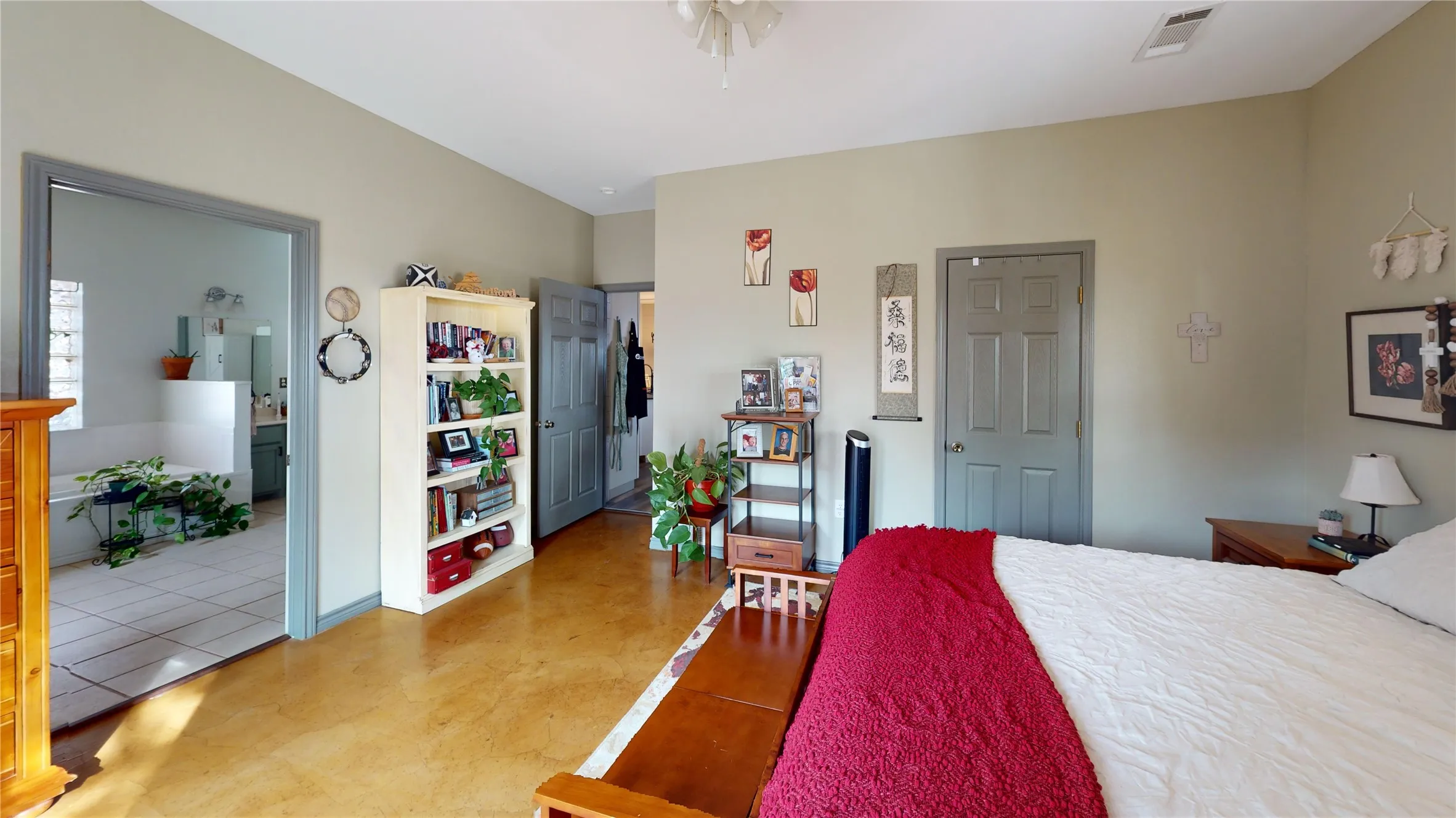 Bedroom with a closet, concrete floors, and ensuite bathroom