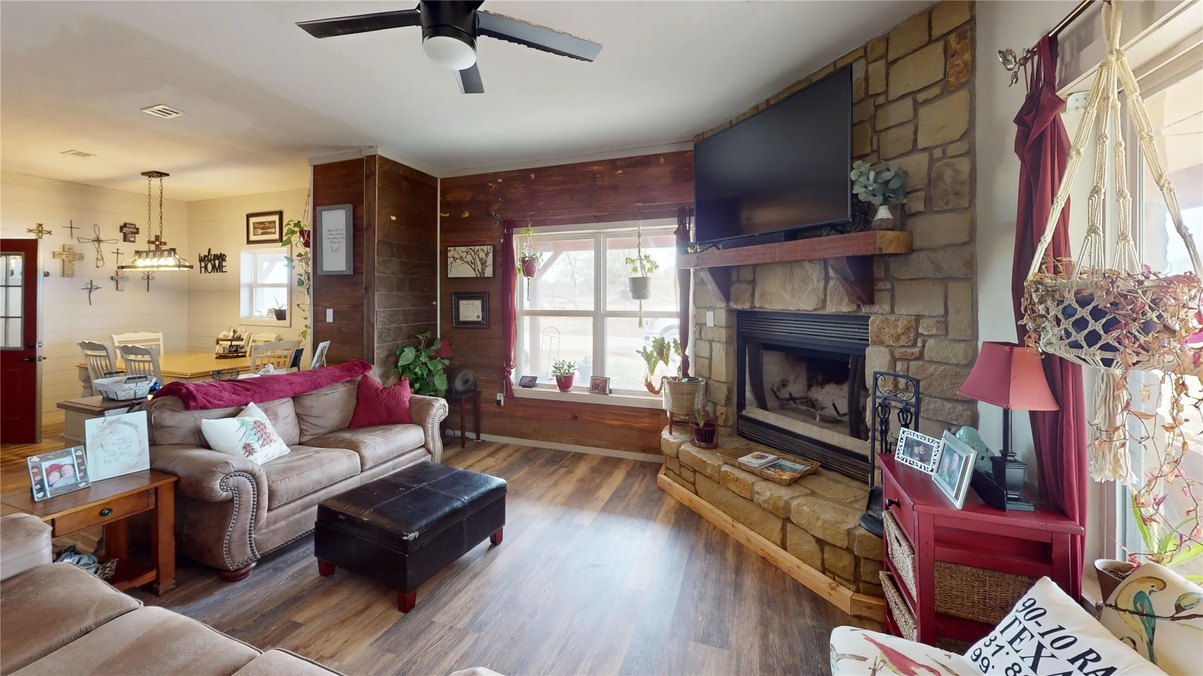 Living area featuring wood finished floors, a fireplace, and a ceiling fan