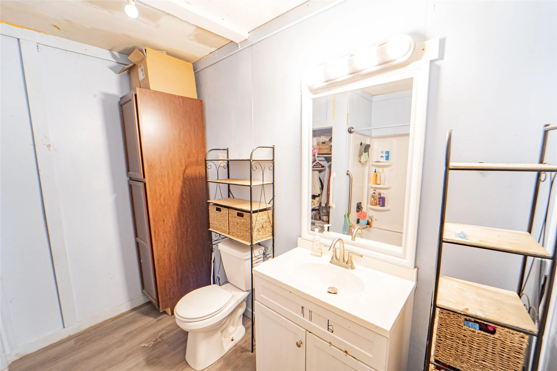 Half bathroom featuring vanity and light wood-type flooring