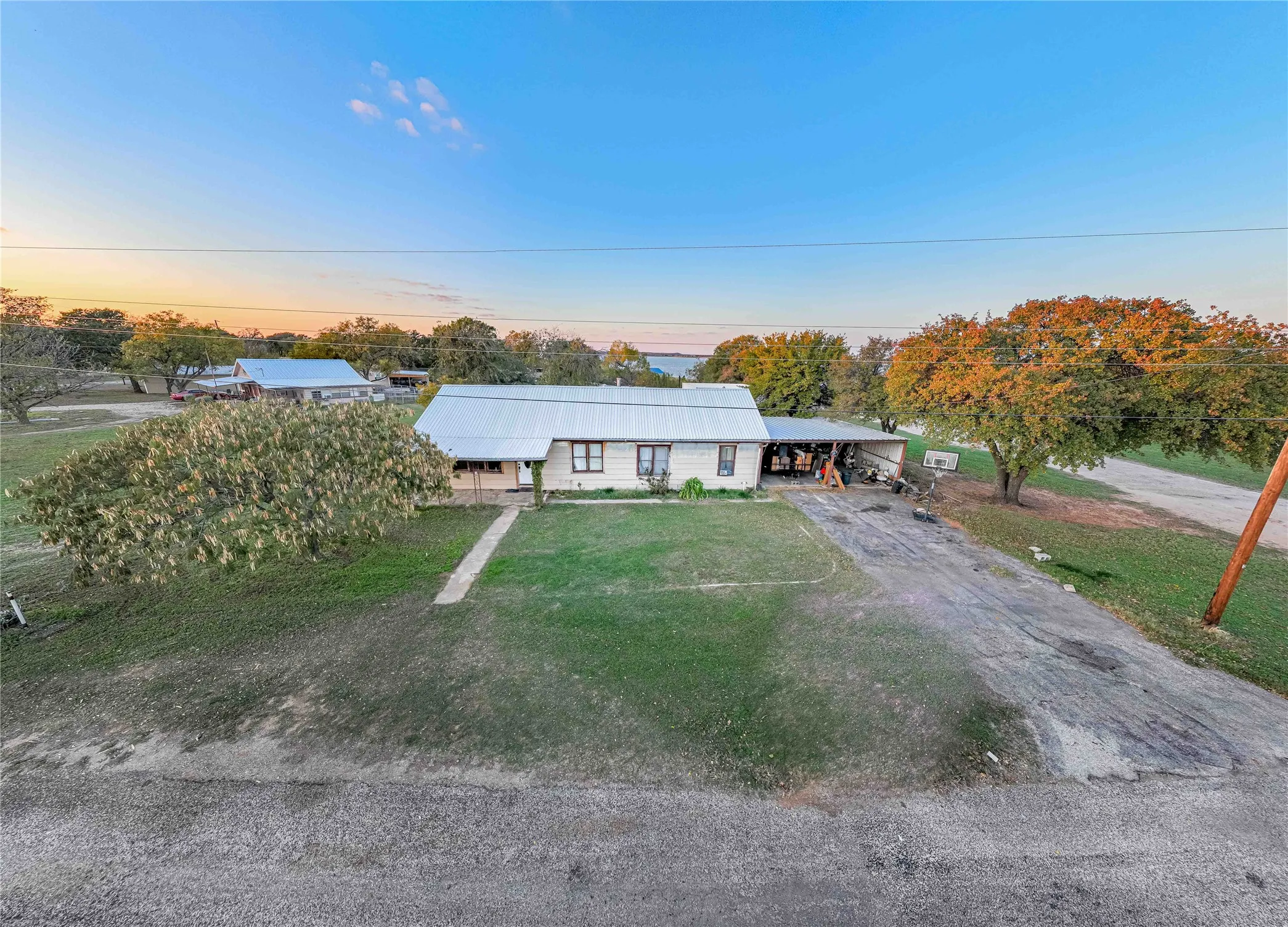 View of front facade featuring a front yard, driveway, and a carport