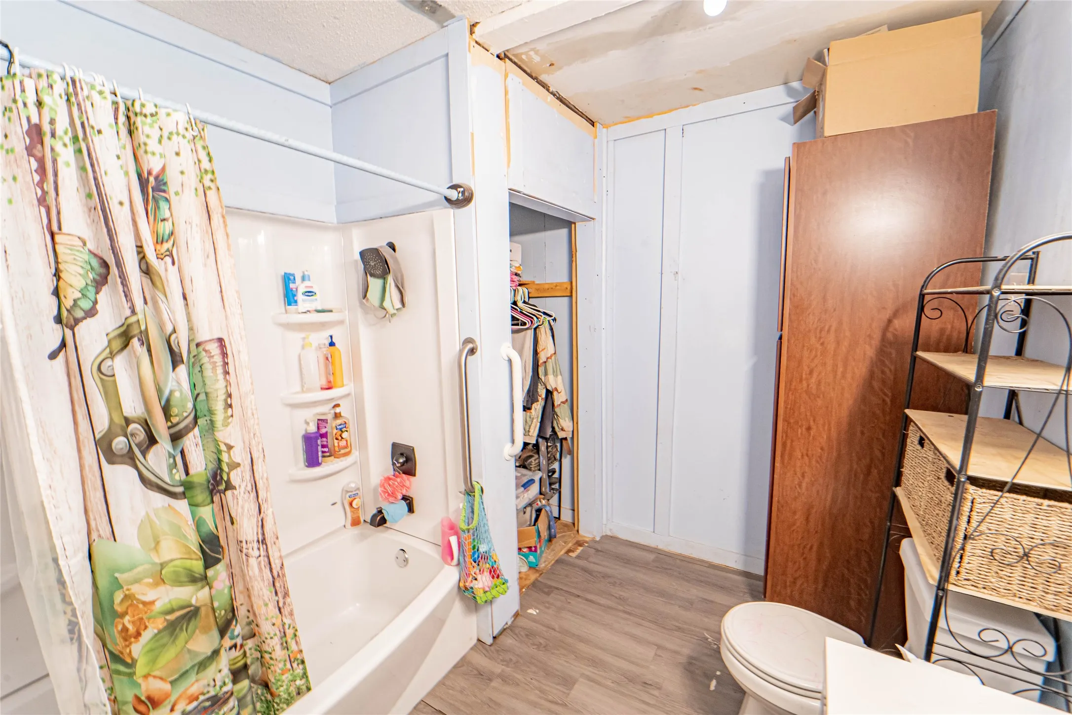 Bathroom featuring light wood-style flooring and shower / bath combo