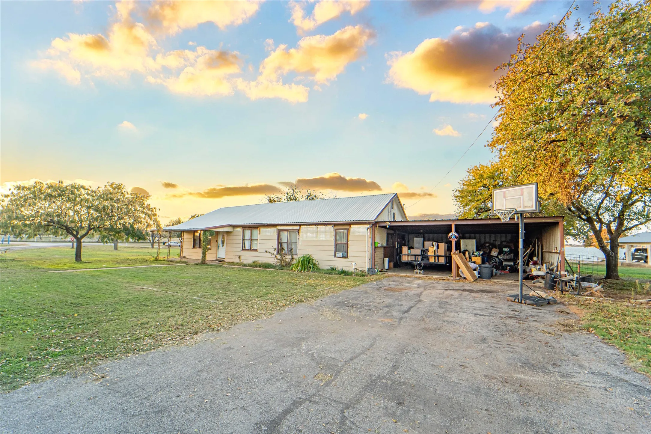 View of front of property with a front lawn, driveway, a metal roof, and a carport