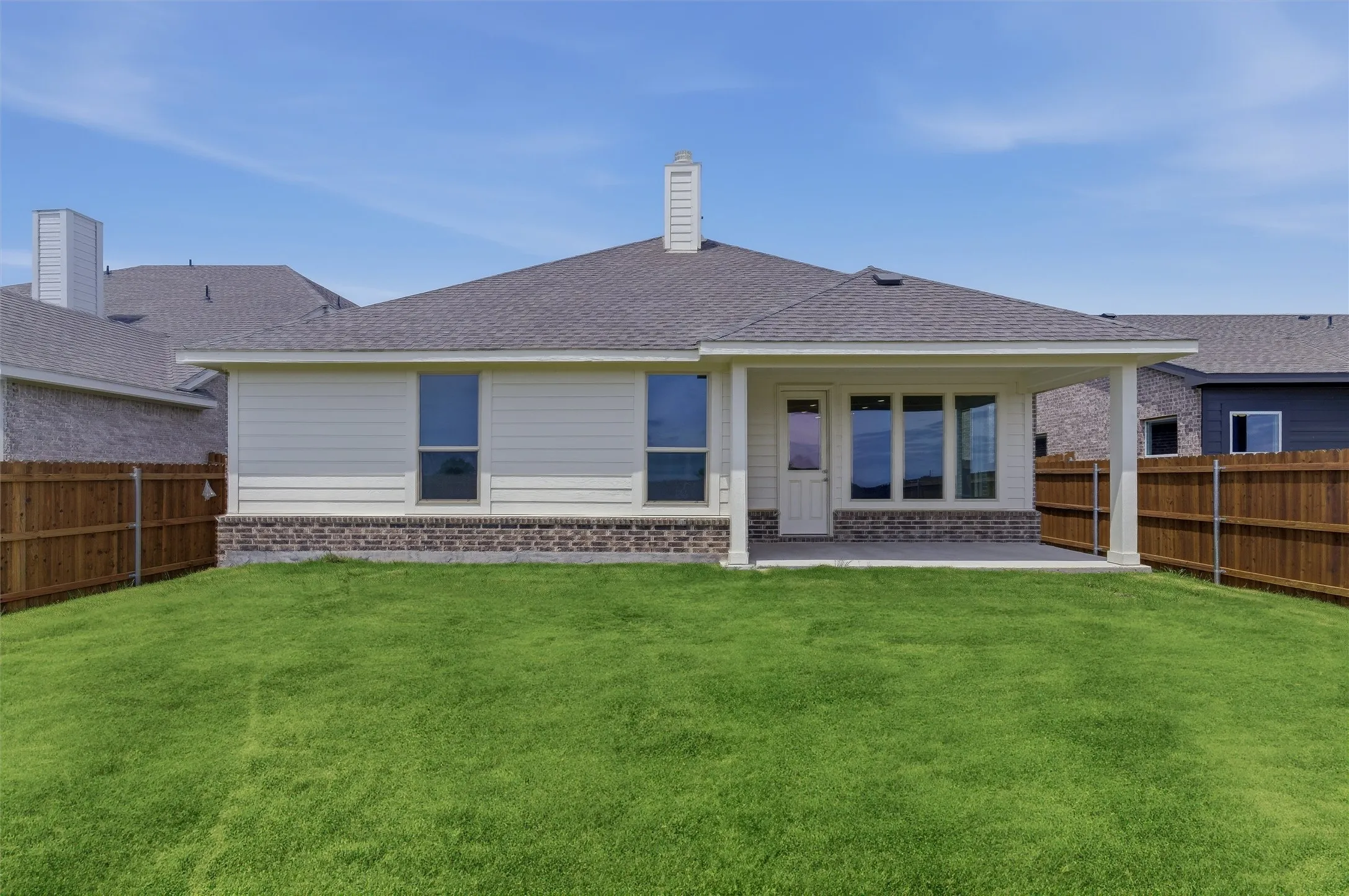 Expansive backyard with a covered patio and wood privacy fencing