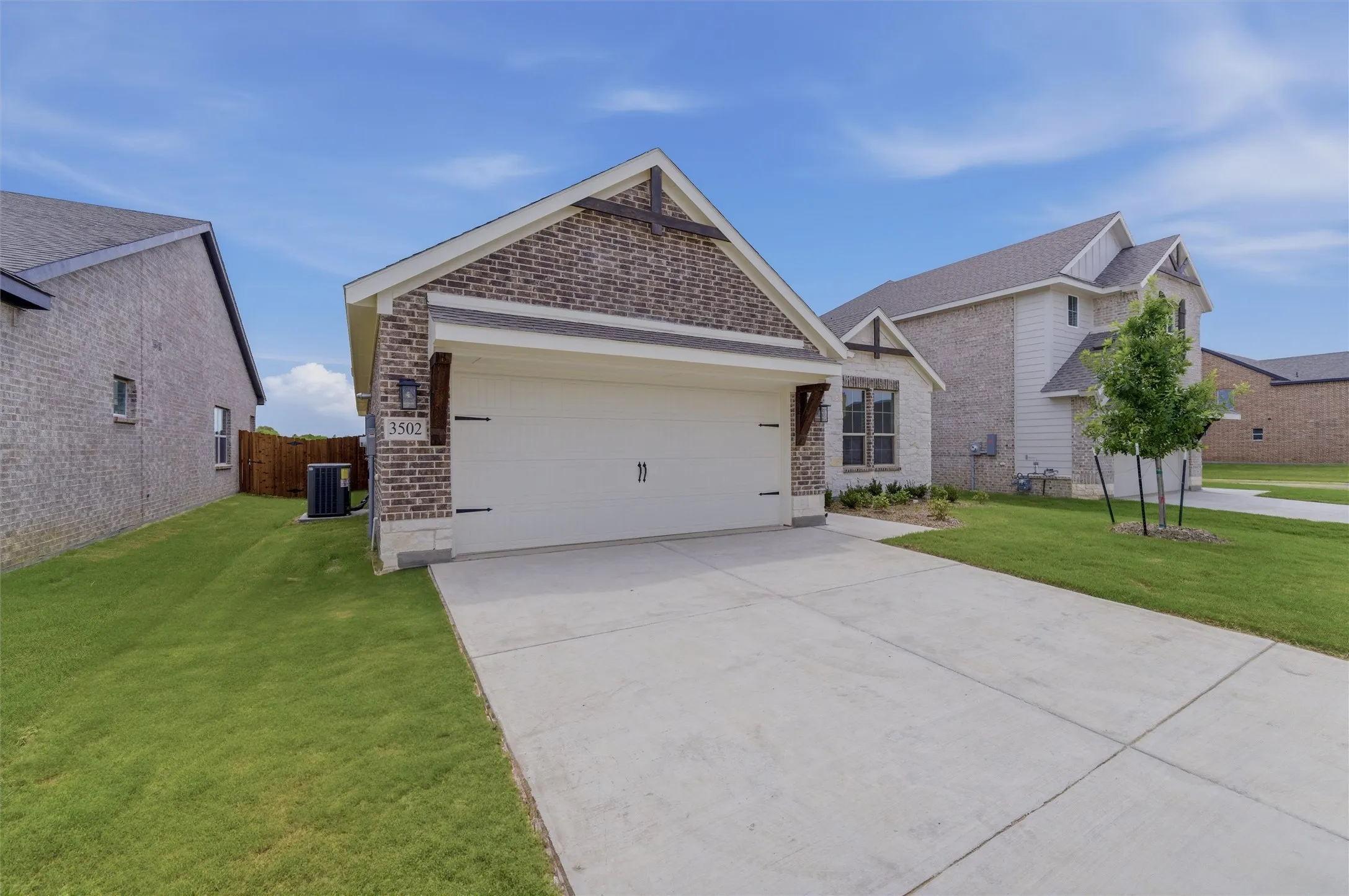 Contemporary brick and stone exterior with a two-car garage