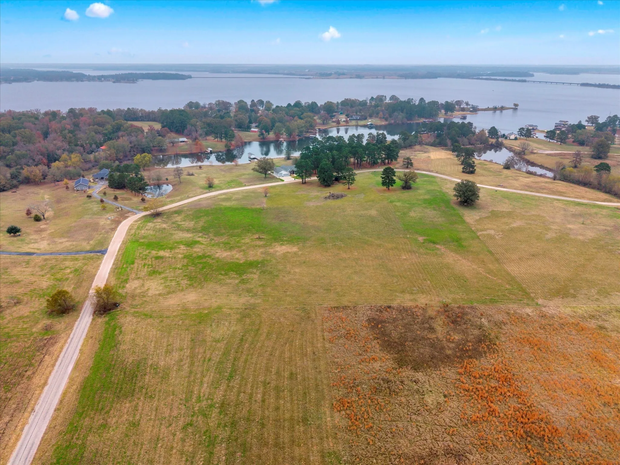 Aerial view of property and surrounding area featuring a large body of water and rural landscape