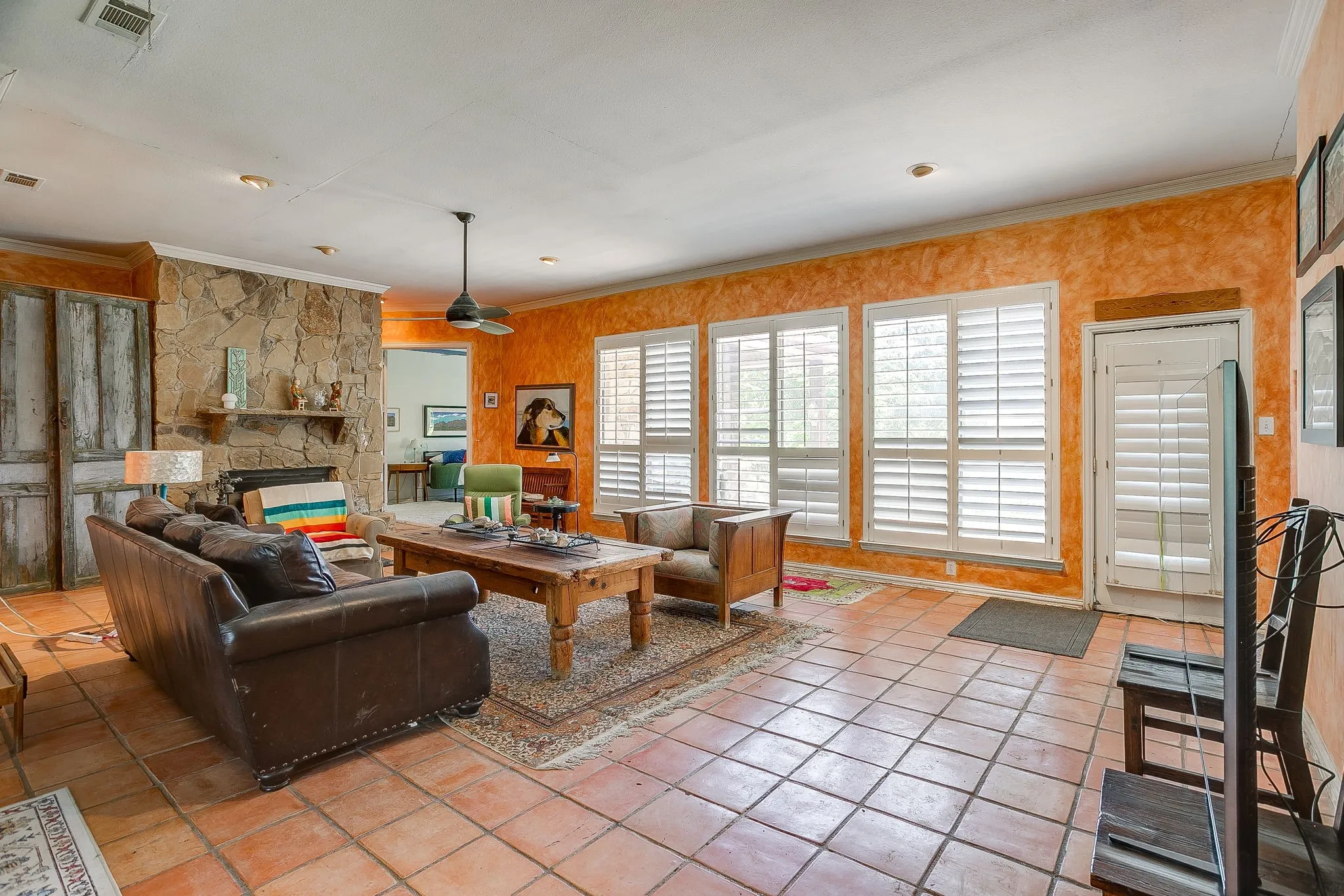 Central to the house is large living room with wall of windows and stone fireplace