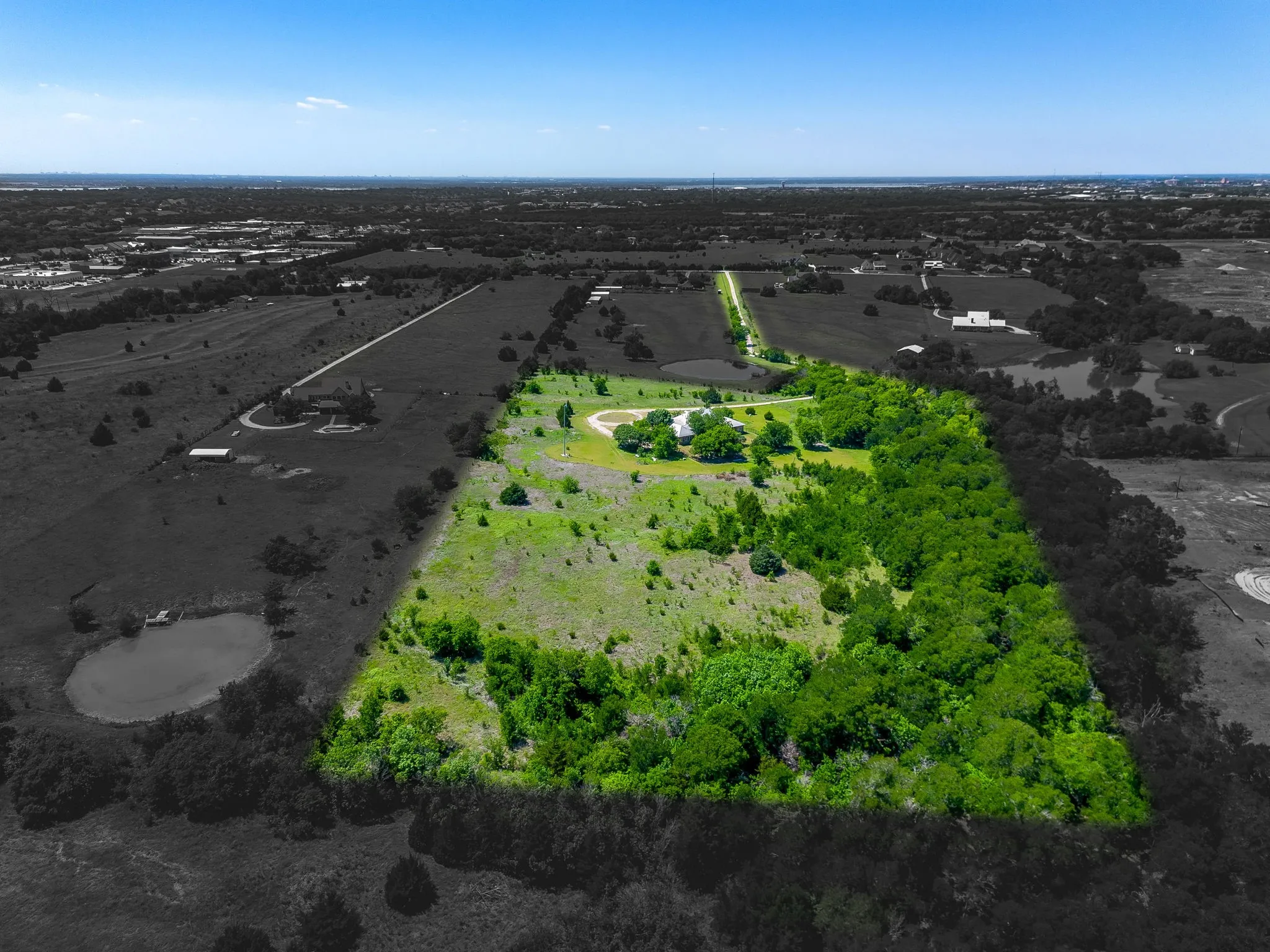 View of property from the backside showing the small forest and grasslands