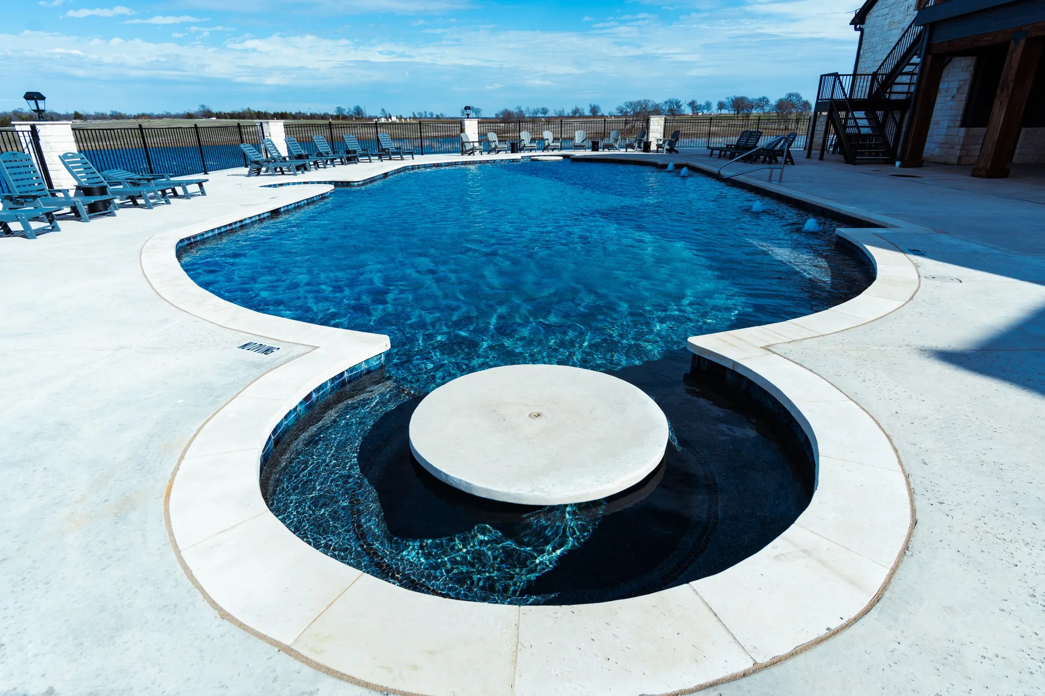 Community pool featuring stairs, fence, and a patio