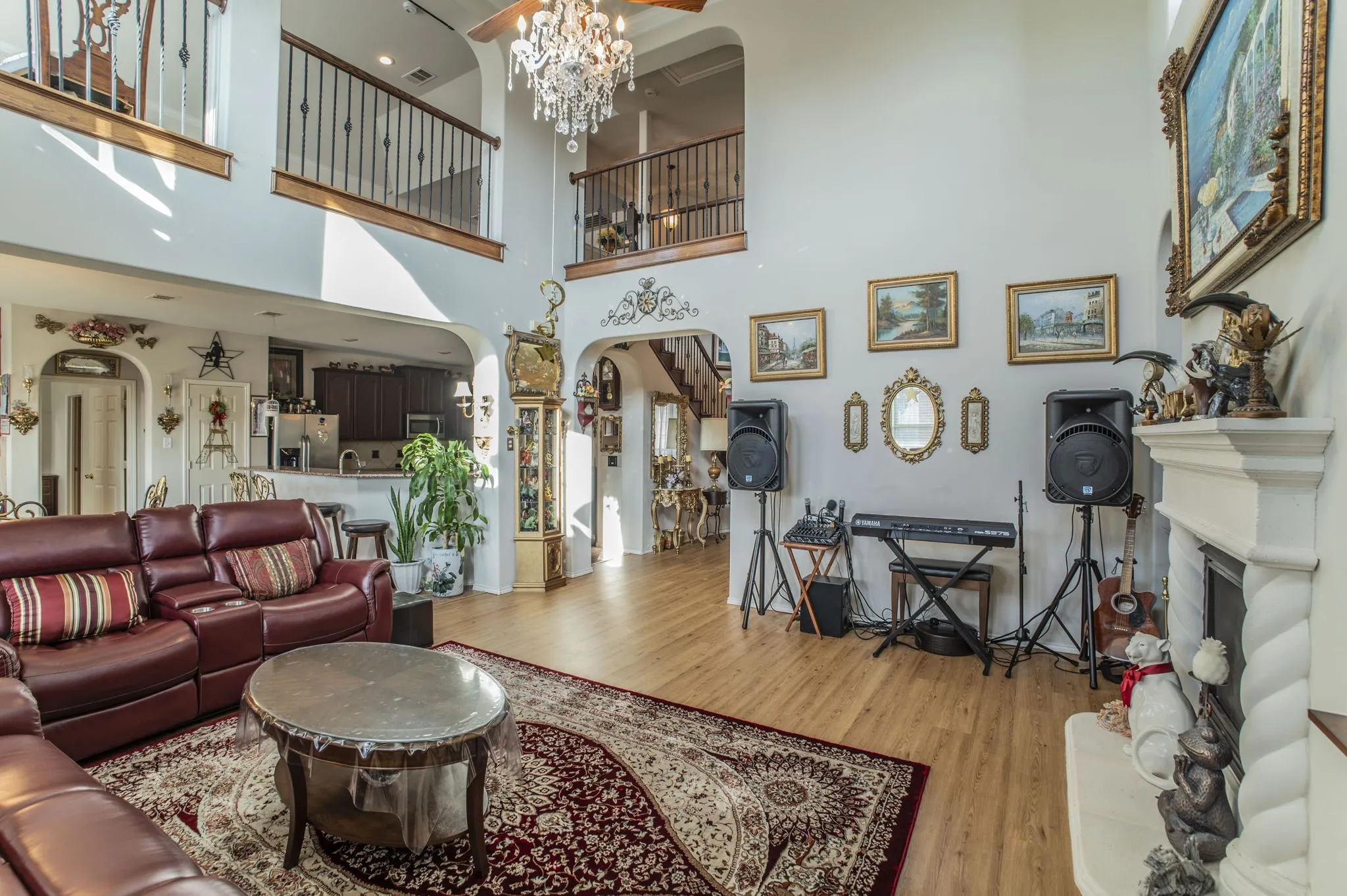 Living area featuring arched walkways, a fireplace, a chandelier, and light wood-style floors