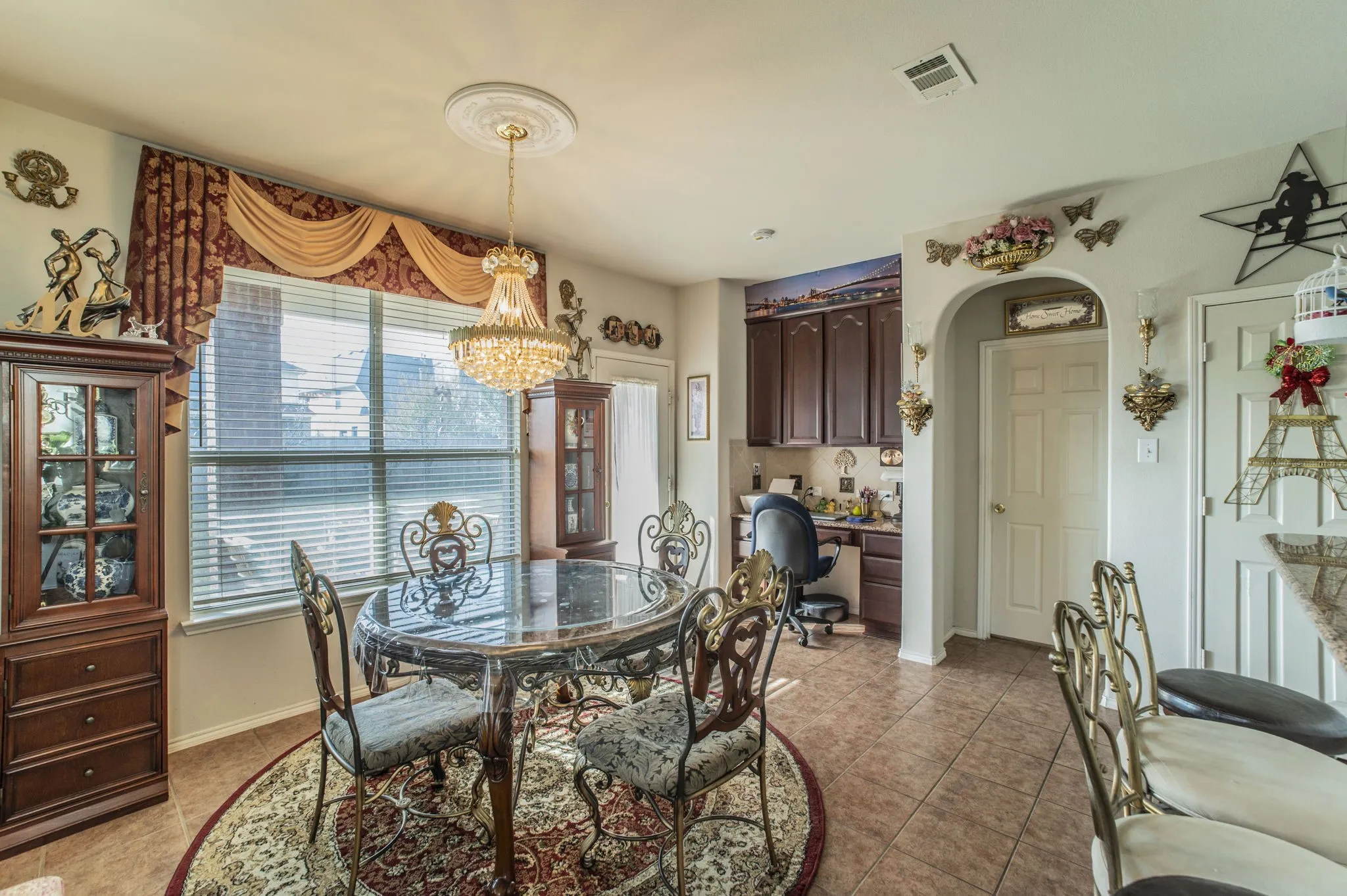 Dining space with light tile patterned floors, a chandelier, and arched walkways