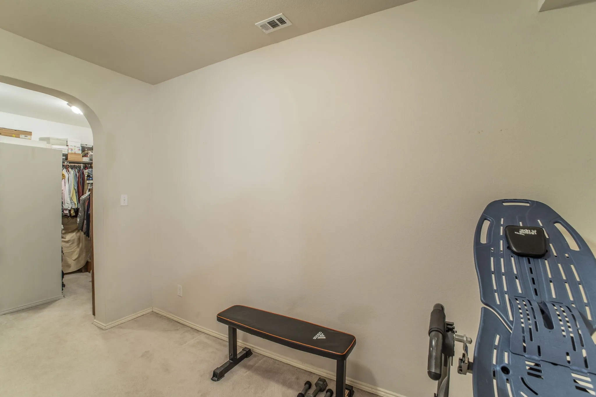 Workout room with arched walkways and carpet flooring
