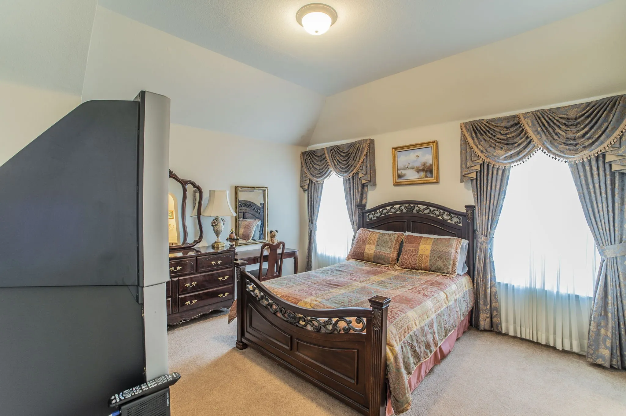Bedroom featuring light carpet and vaulted ceiling