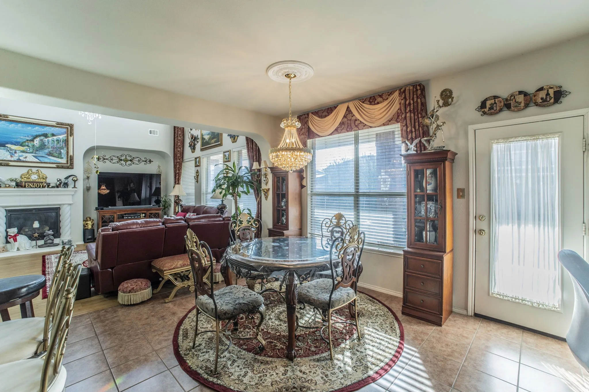 Dining area featuring light tile patterned floors, a glass covered fireplace, and a chandelier