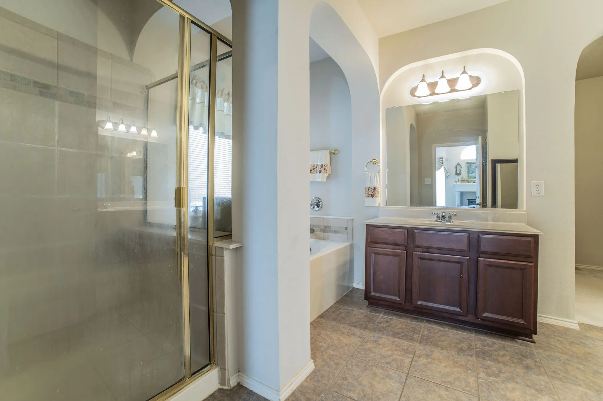 Bathroom with vanity, a garden tub, and a shower stall