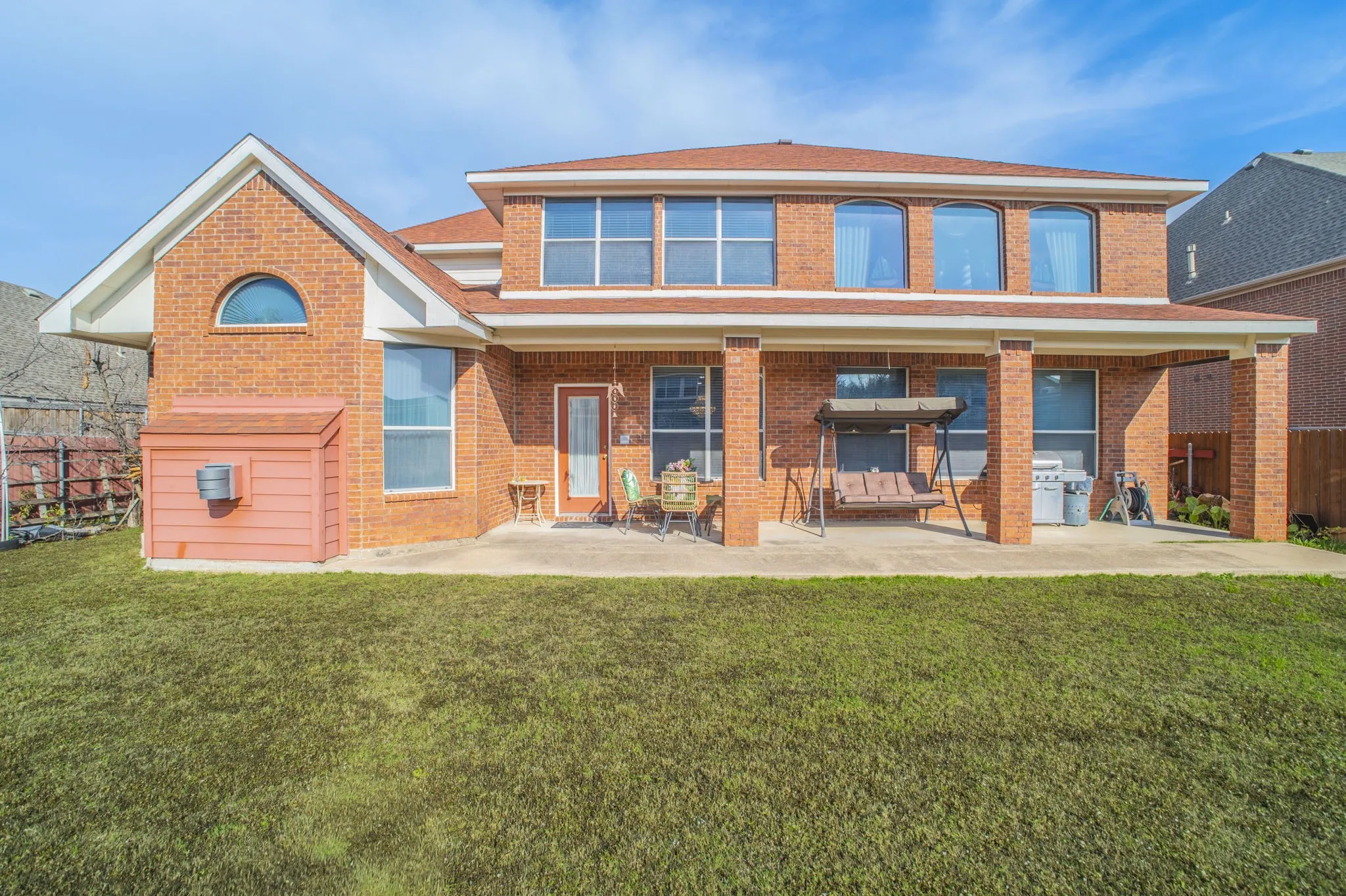 Rear view of house with brick siding and a patio area