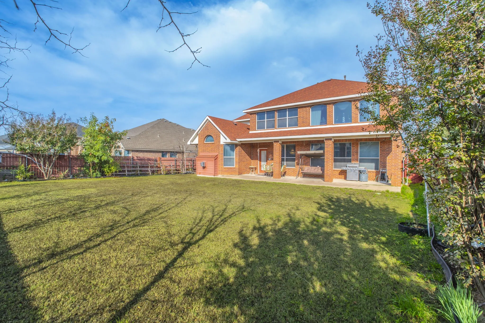 Rear view of house with brick siding and a patio