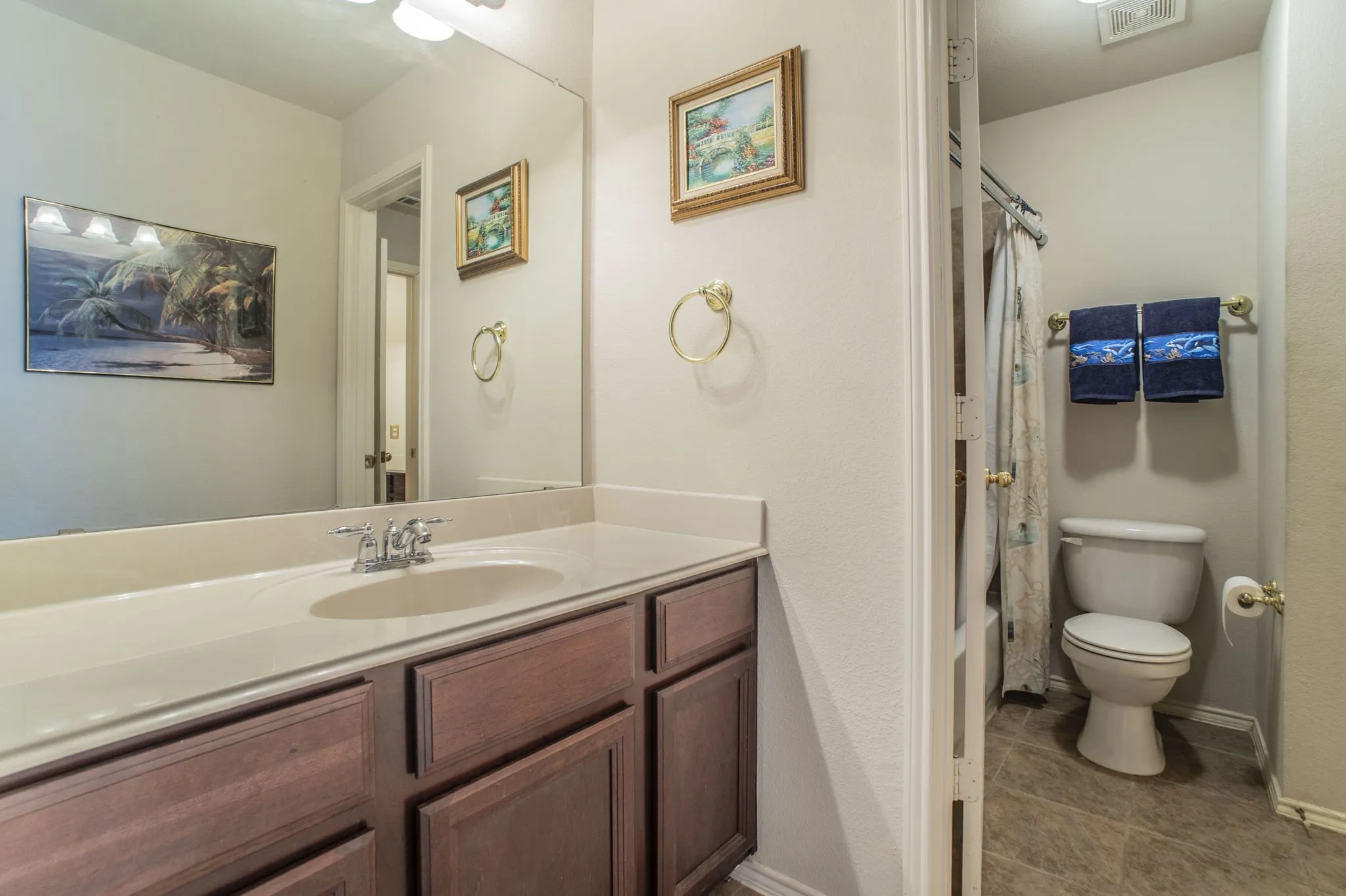 Bathroom with vanity, tile patterned floors, and shower / bathtub combination with curtain
