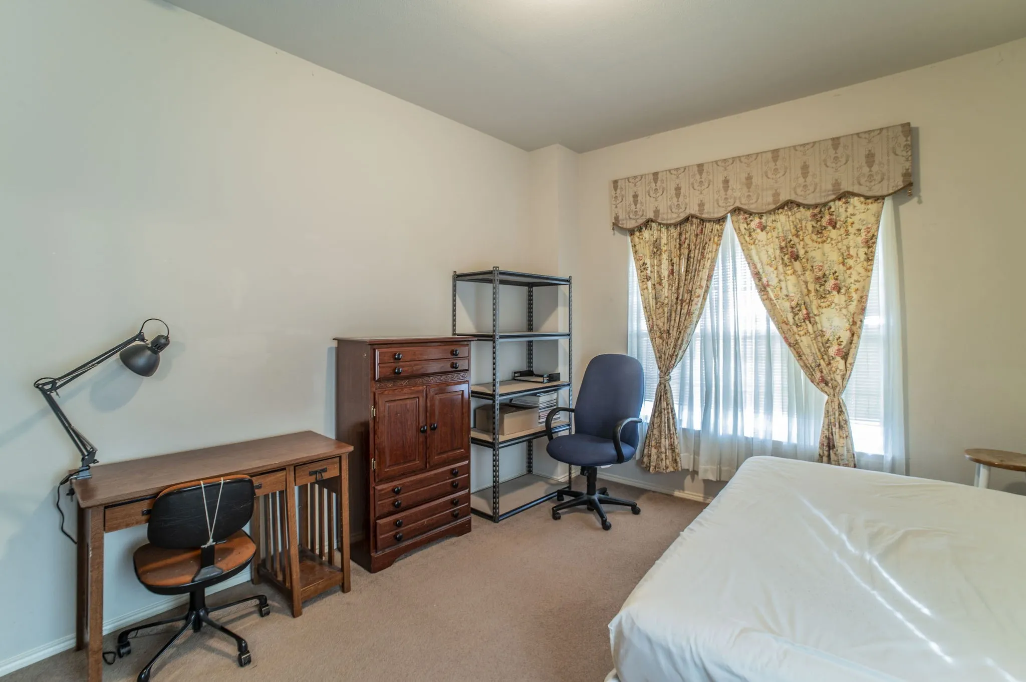 Bedroom featuring an office area and light carpet