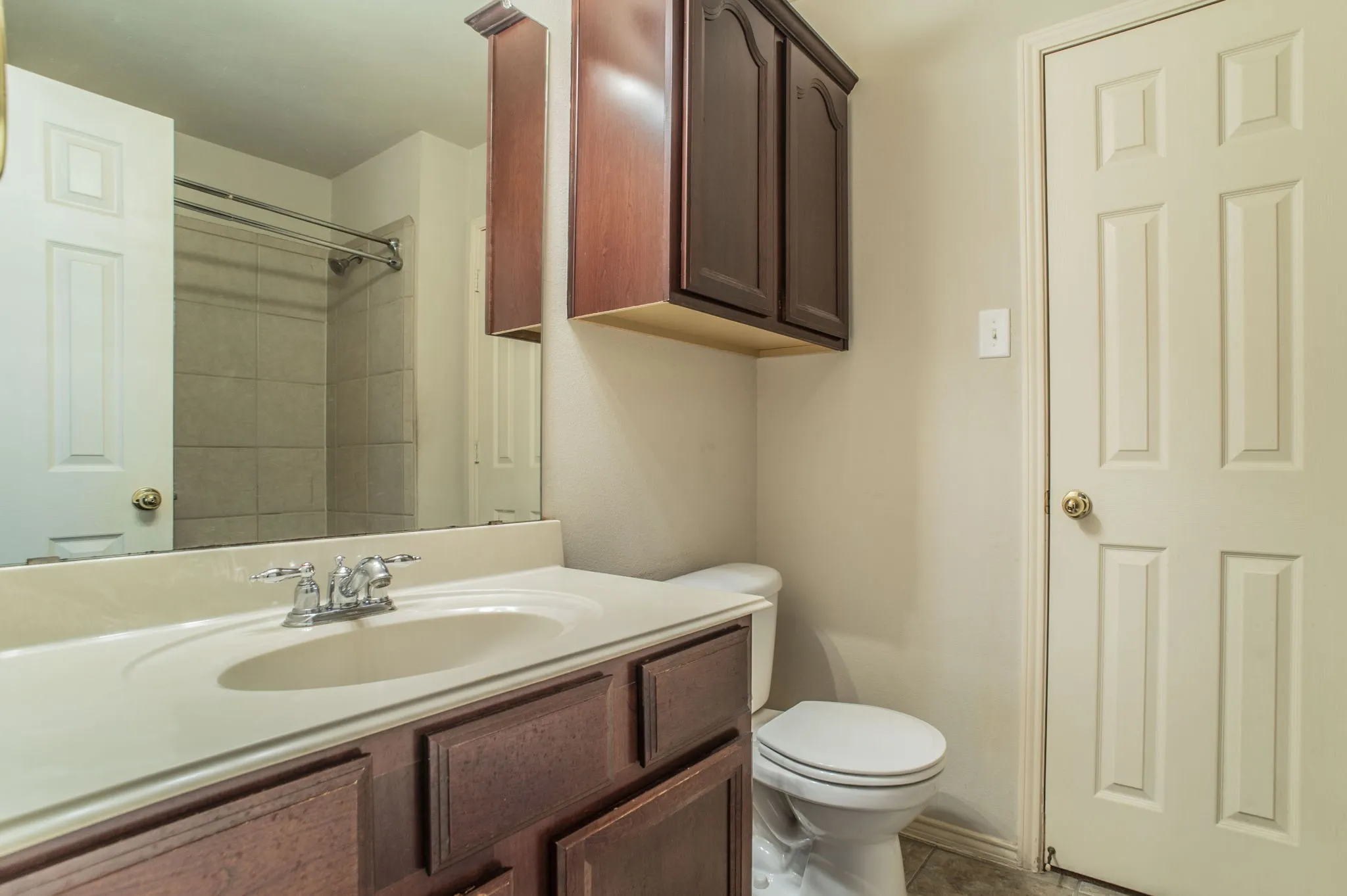 Bathroom with vanity, a shower, and tile patterned flooring