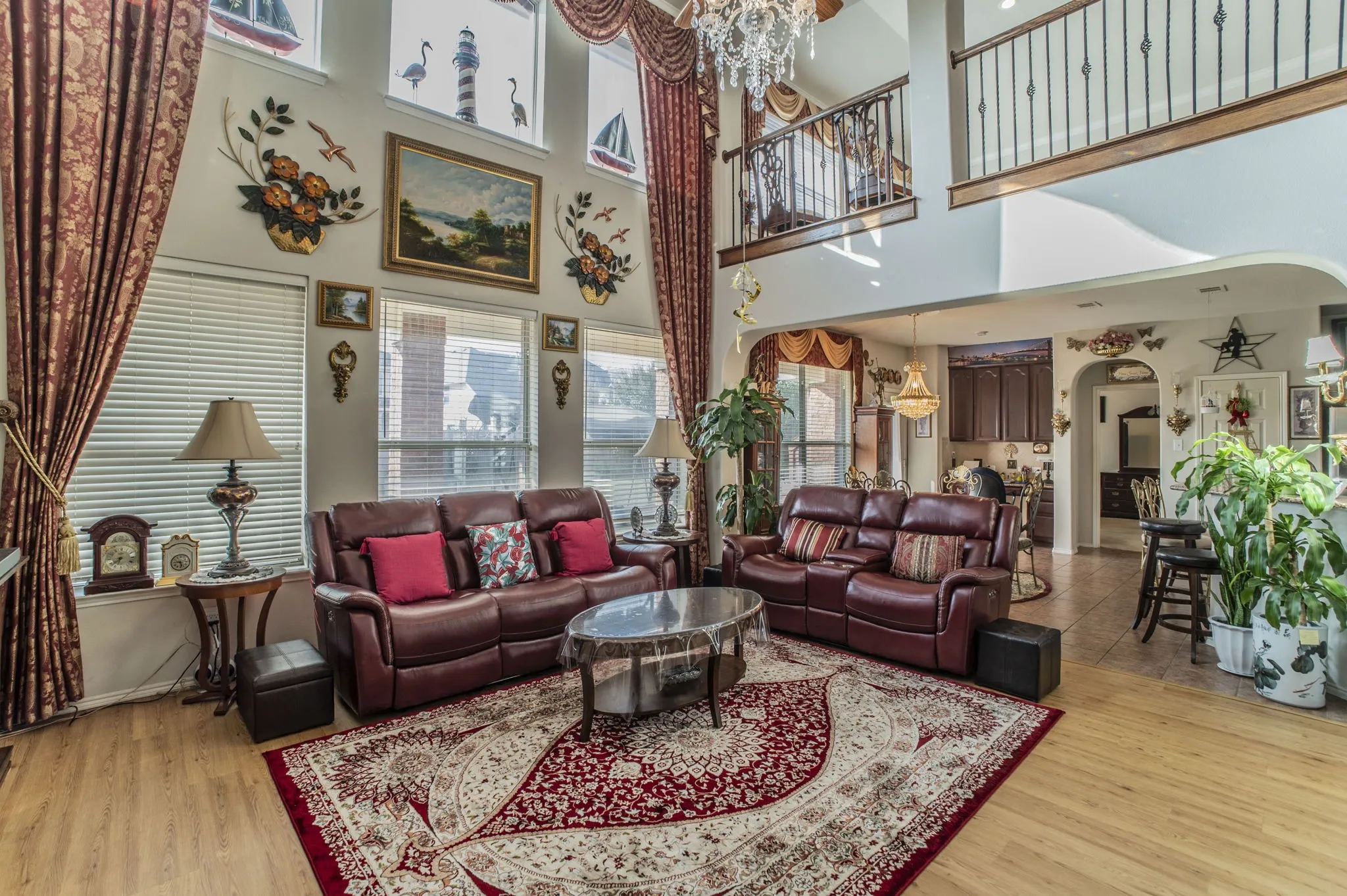Living room with a chandelier, arched walkways, and light wood finished floors