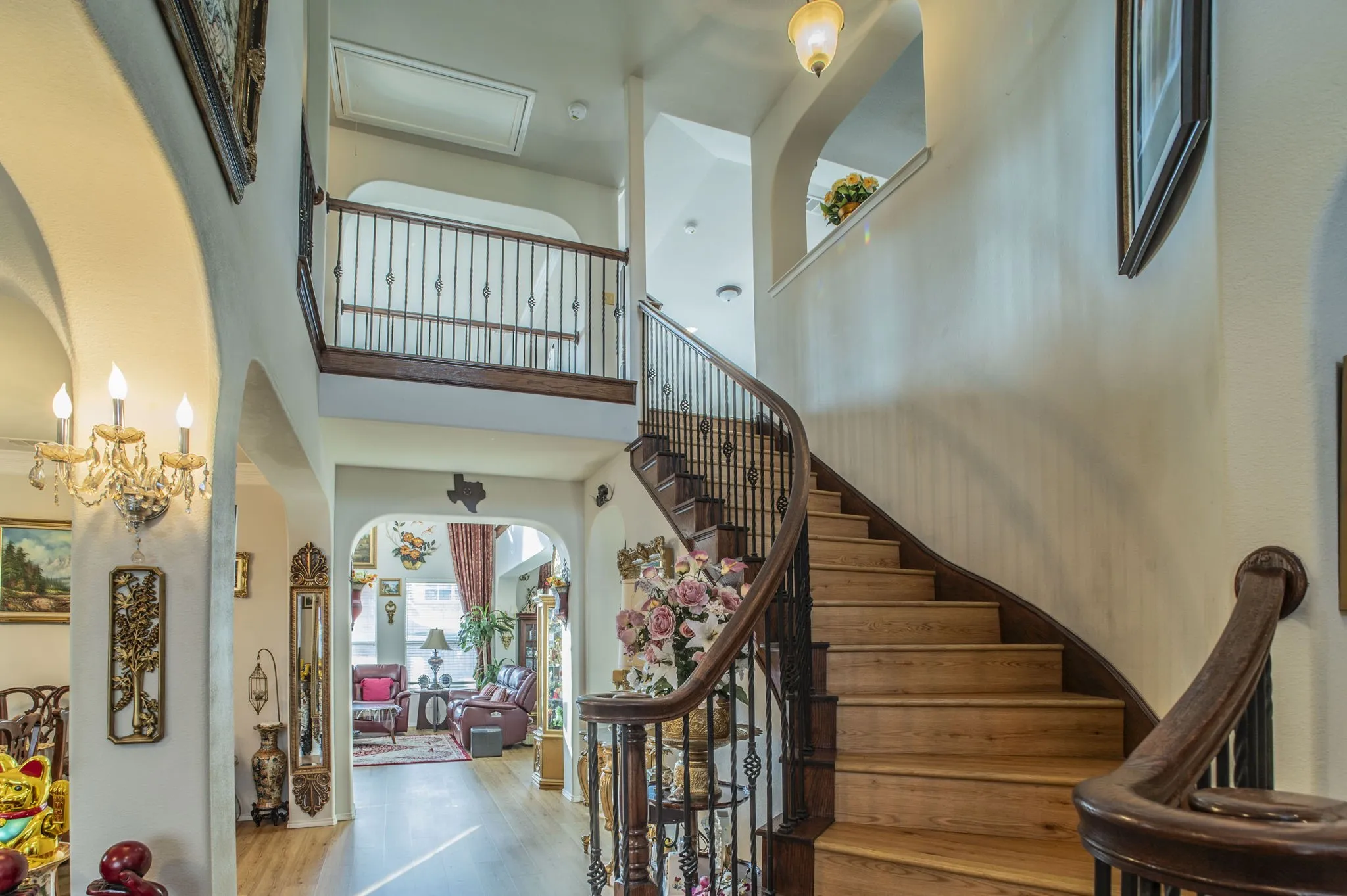 Entrance foyer featuring arched walkways, a towering ceiling, and wood finished floors