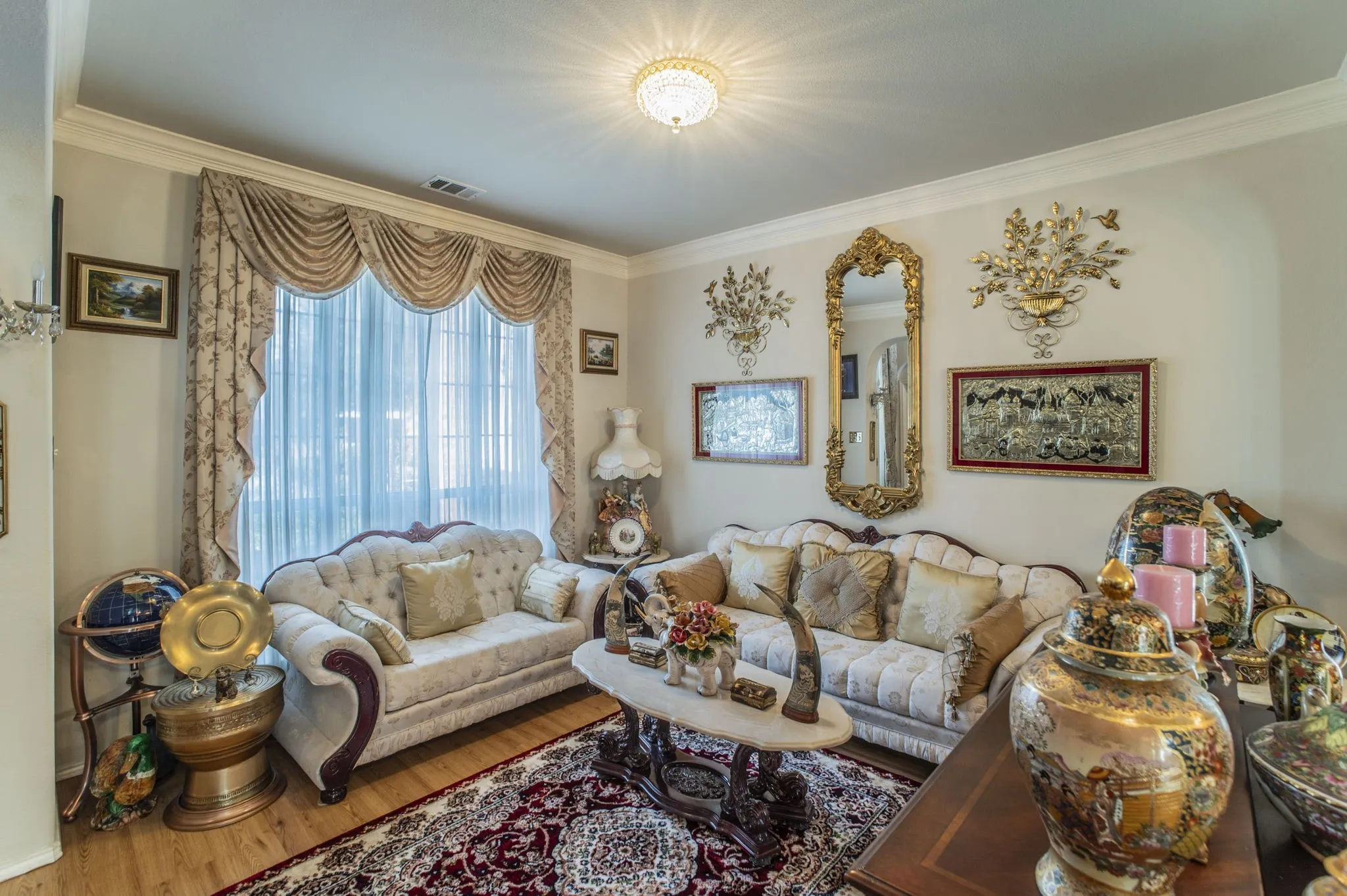 Living area with wood finished floors and ornamental molding