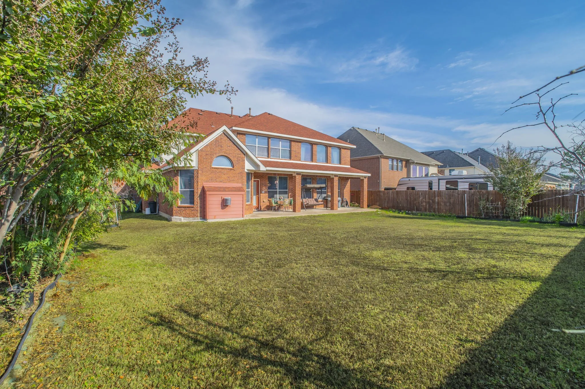Back of property featuring brick siding, a patio, and a fenced backyard