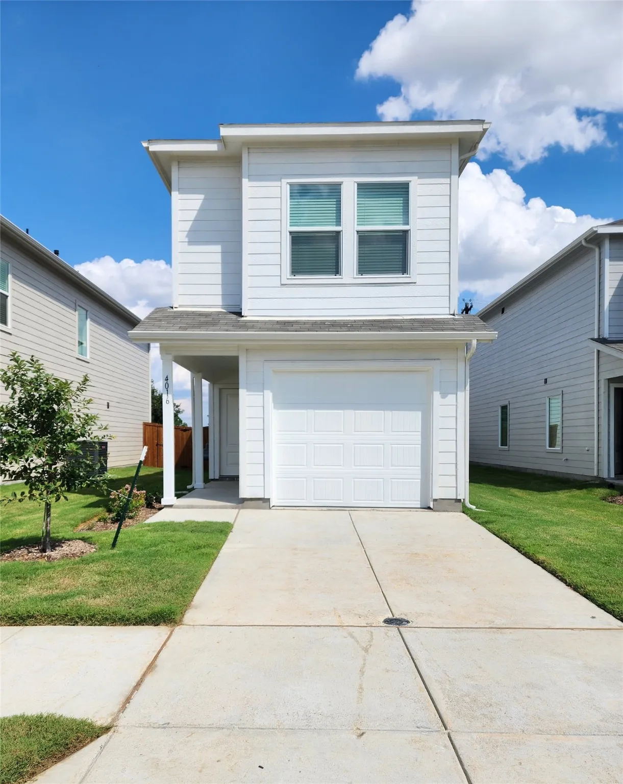 Traditional home with concrete driveway, a garage, and a front yard