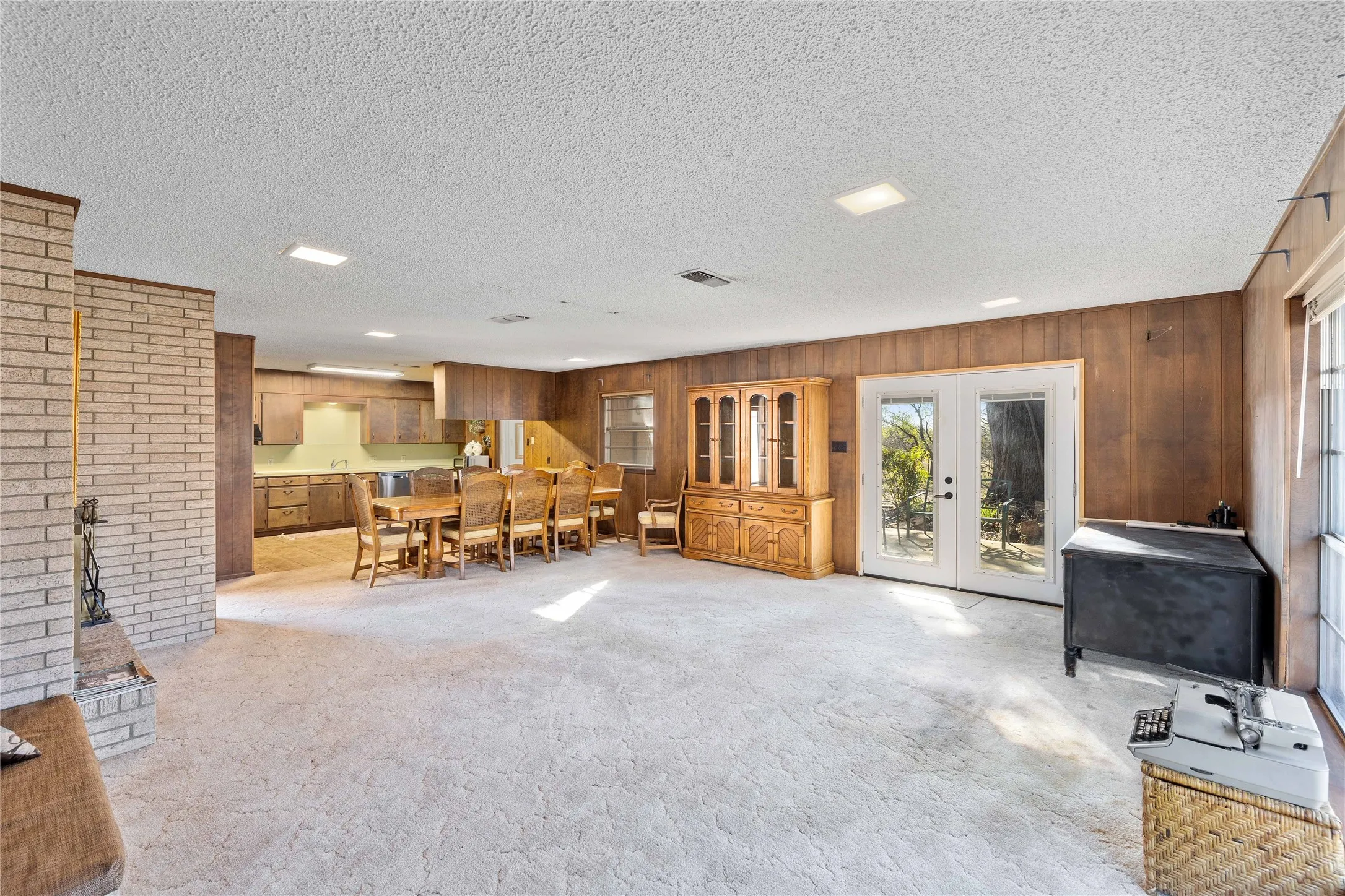 Den with brick wood-burning fireplace
