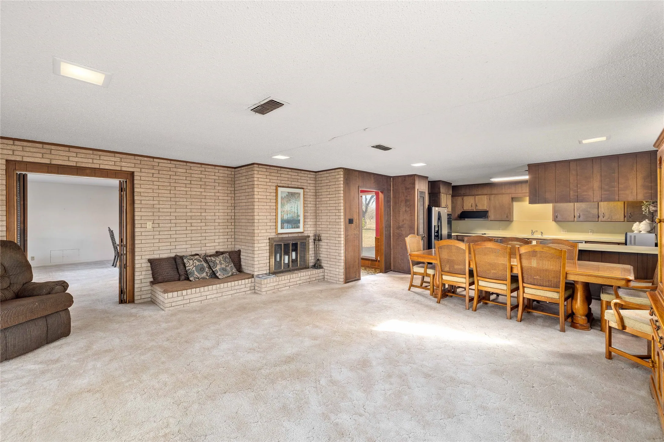 Den with brick wood-burning fireplace