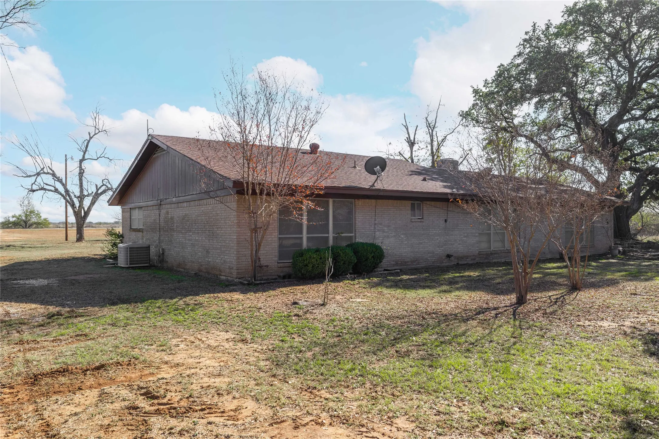 Back of the brick home with large windows