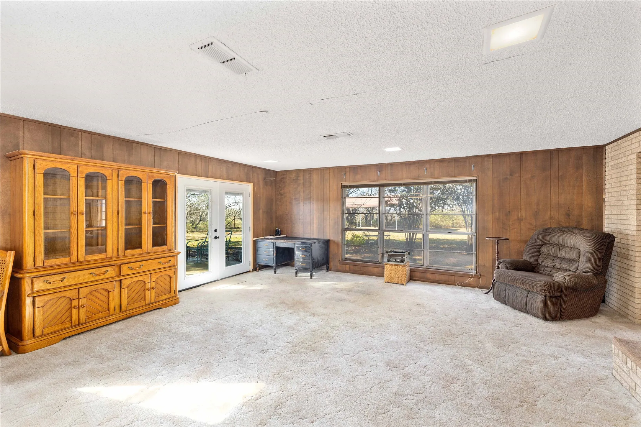 Den with brick wood-burning fireplace
