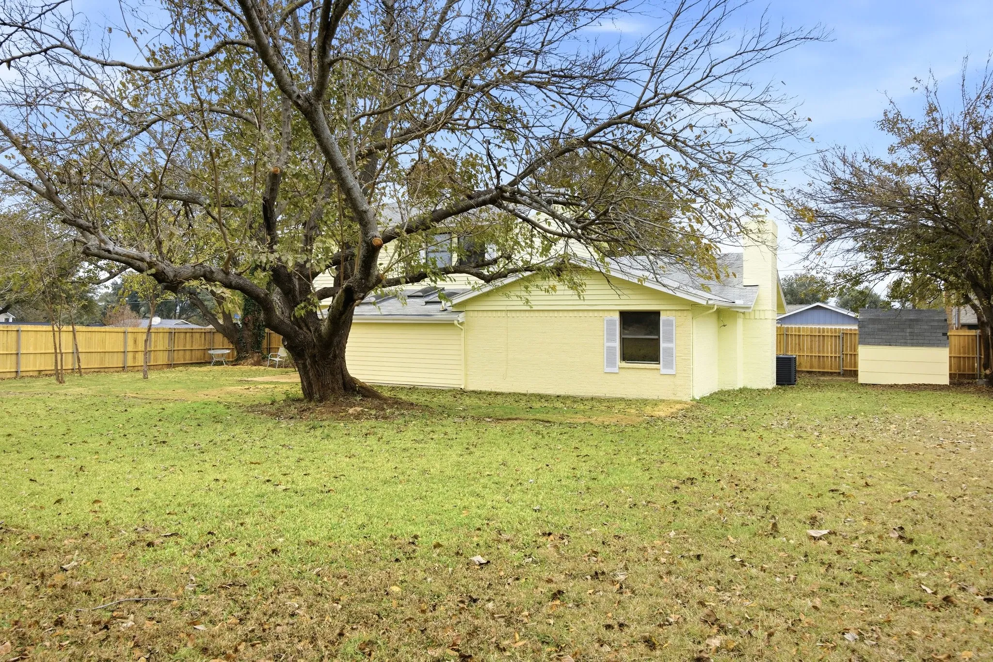 Fenced backyard featuring a storage unit