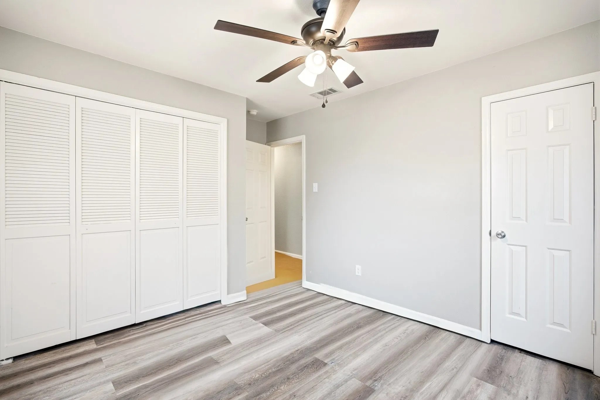 Unfurnished bedroom with a ceiling fan, light wood-style flooring, and a closet