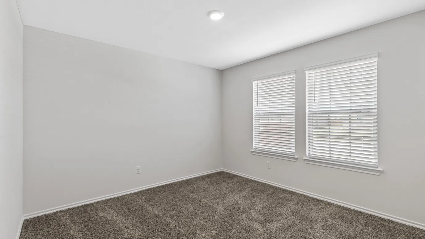 Unfurnished room featuring dark colored carpet and baseboards