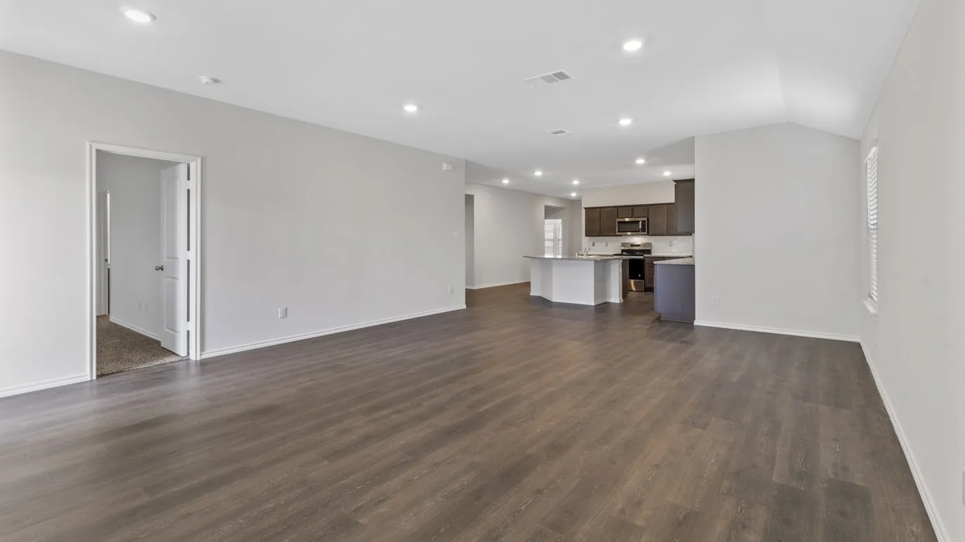 Unfurnished living room with recessed lighting, dark wood finished floors, and vaulted ceiling
