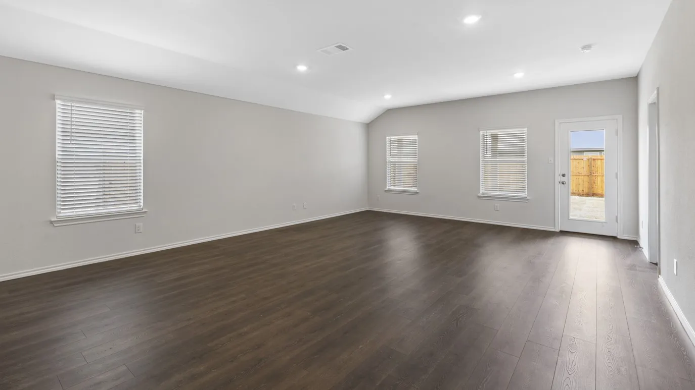 Empty room with dark wood-style flooring, recessed lighting, and vaulted ceiling