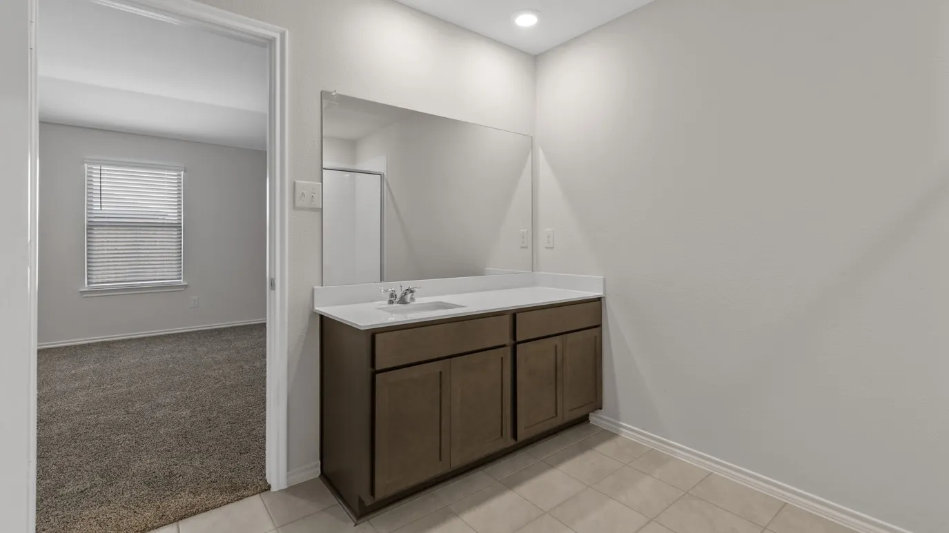 Full bath featuring vanity, light colored carpet, a shower stall, and light tile patterned floors
