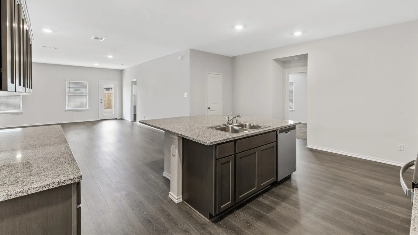 Kitchen featuring dark brown cabinets, open floor plan, a center island with sink, dishwasher, and recessed lighting