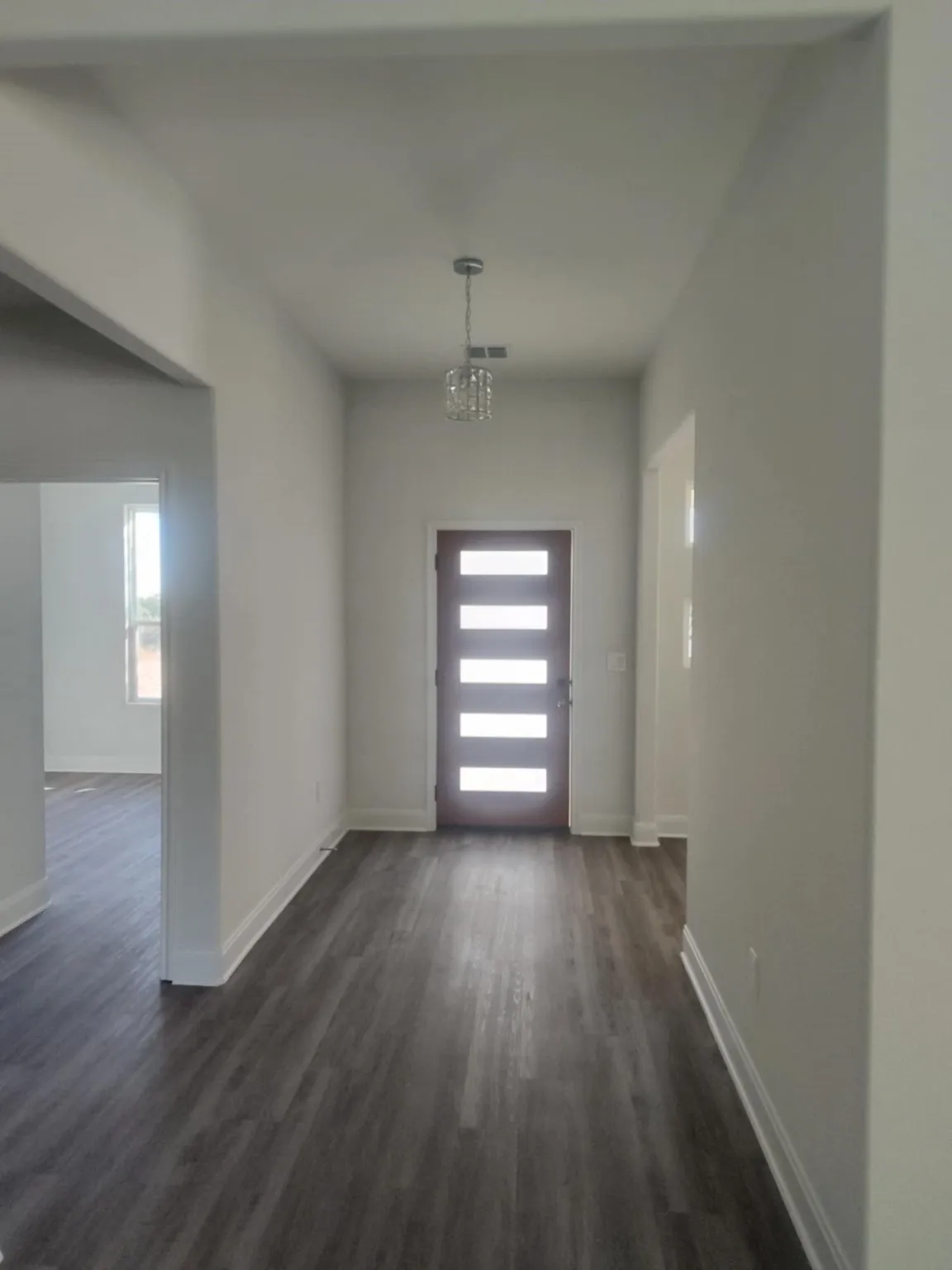 Foyer with dark wood finished floors and baseboards