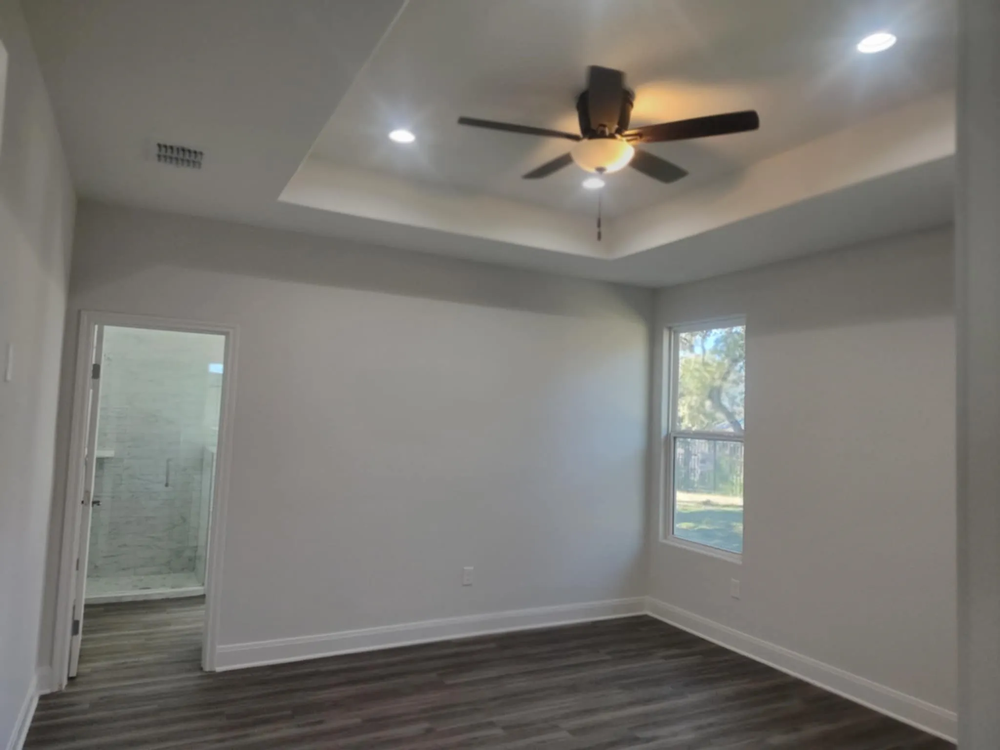  with a tray ceiling, dark wood-type flooring, ceiling fan, and recessed lighting