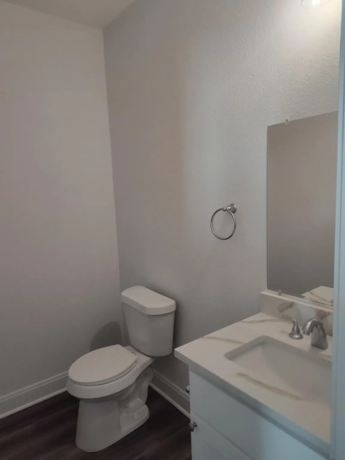 Half bathroom with vanity and dark wood finished floors