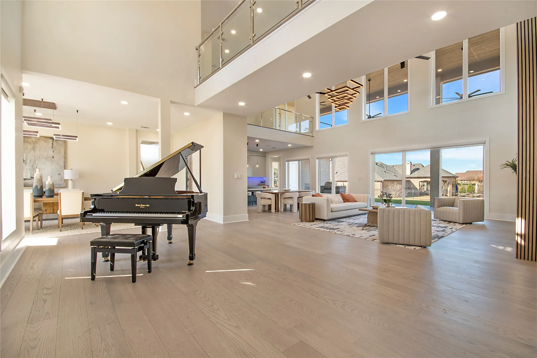 Living area featuring light wood-style floors, a towering ceiling, and recessed lighting