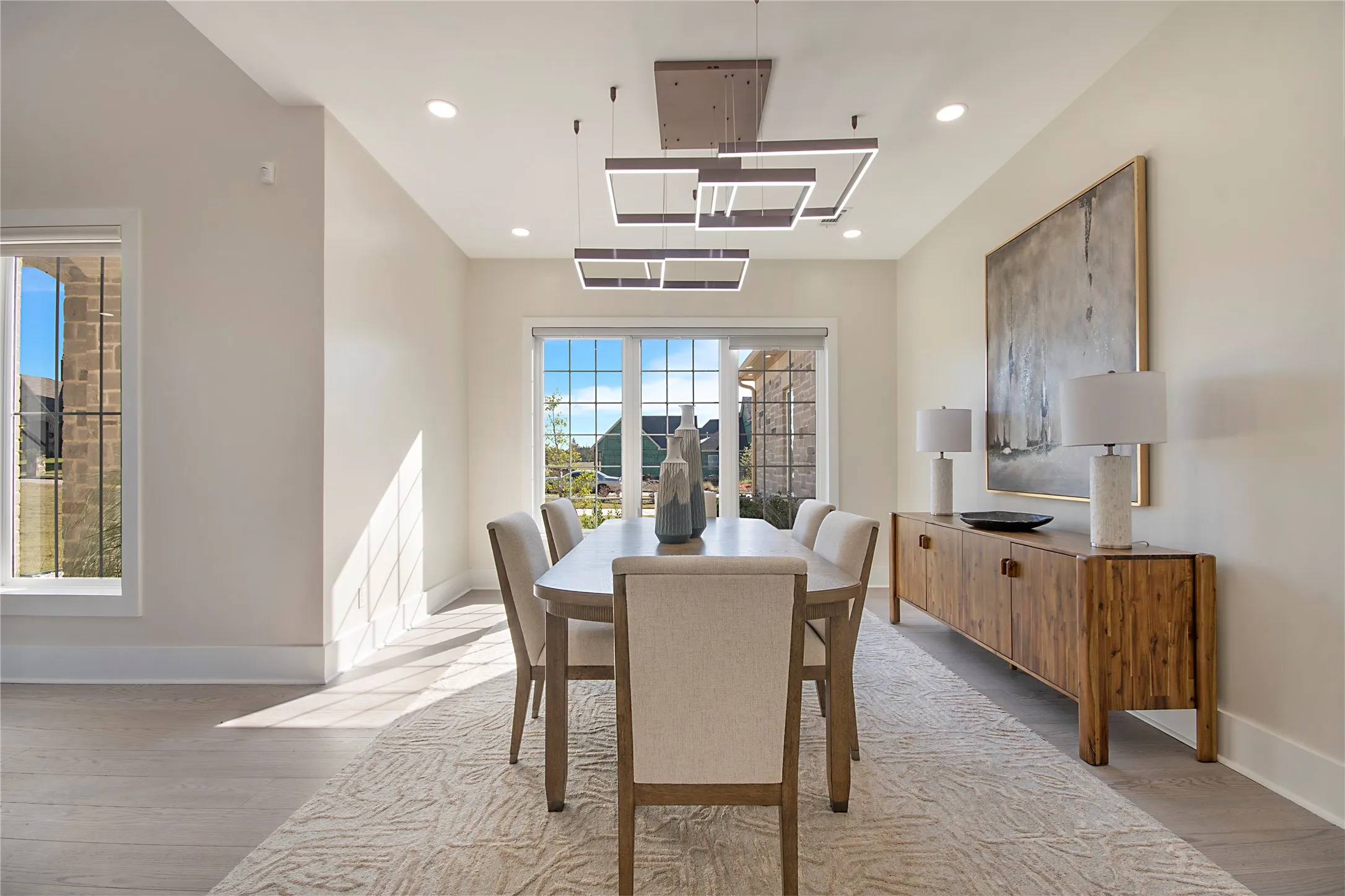 Dining room with light wood finished floors and recessed lighting